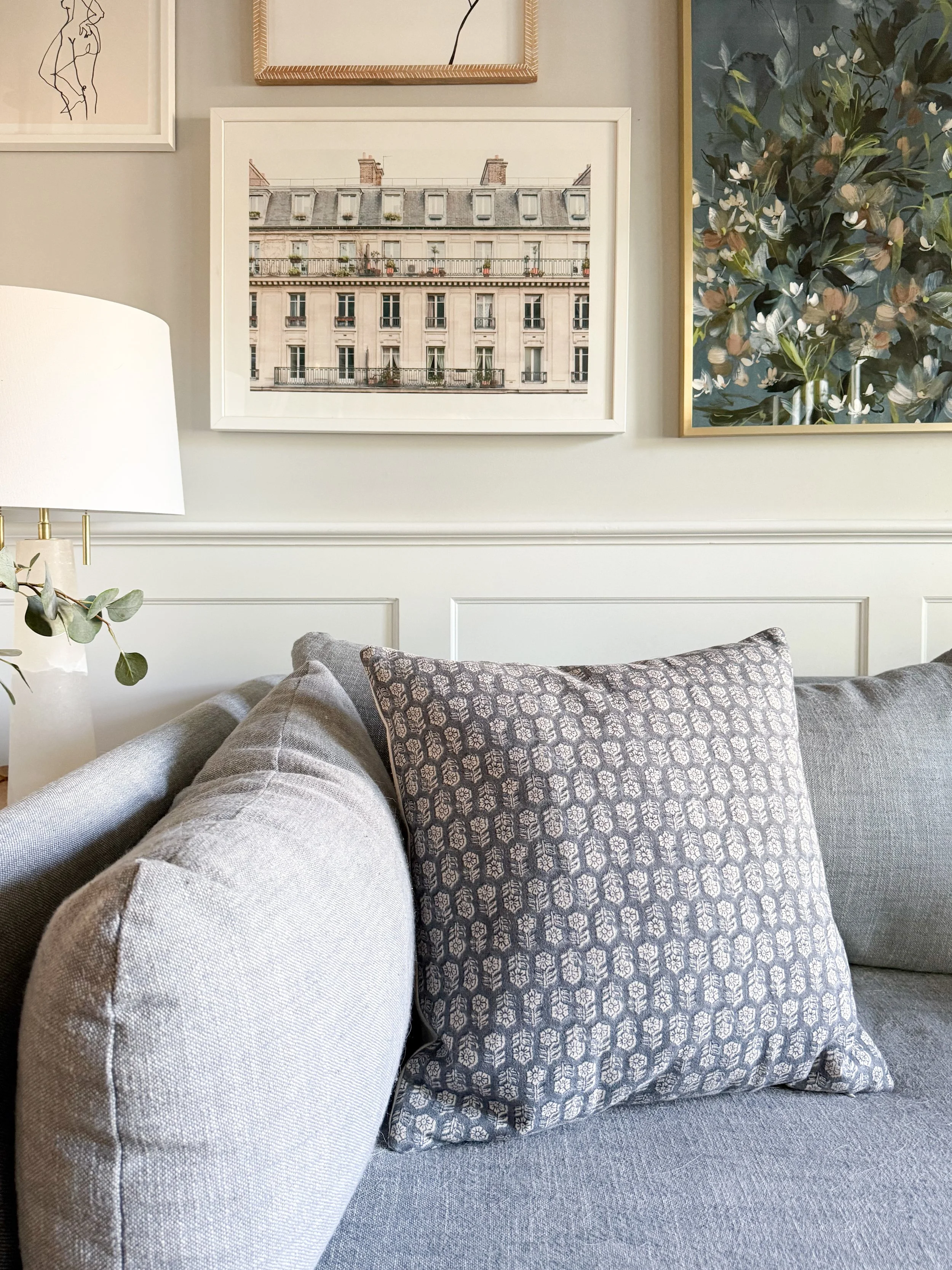 Neutral patterned throw pillows layered on a light colored sofa, adding texture and warmth to a cozy living room.