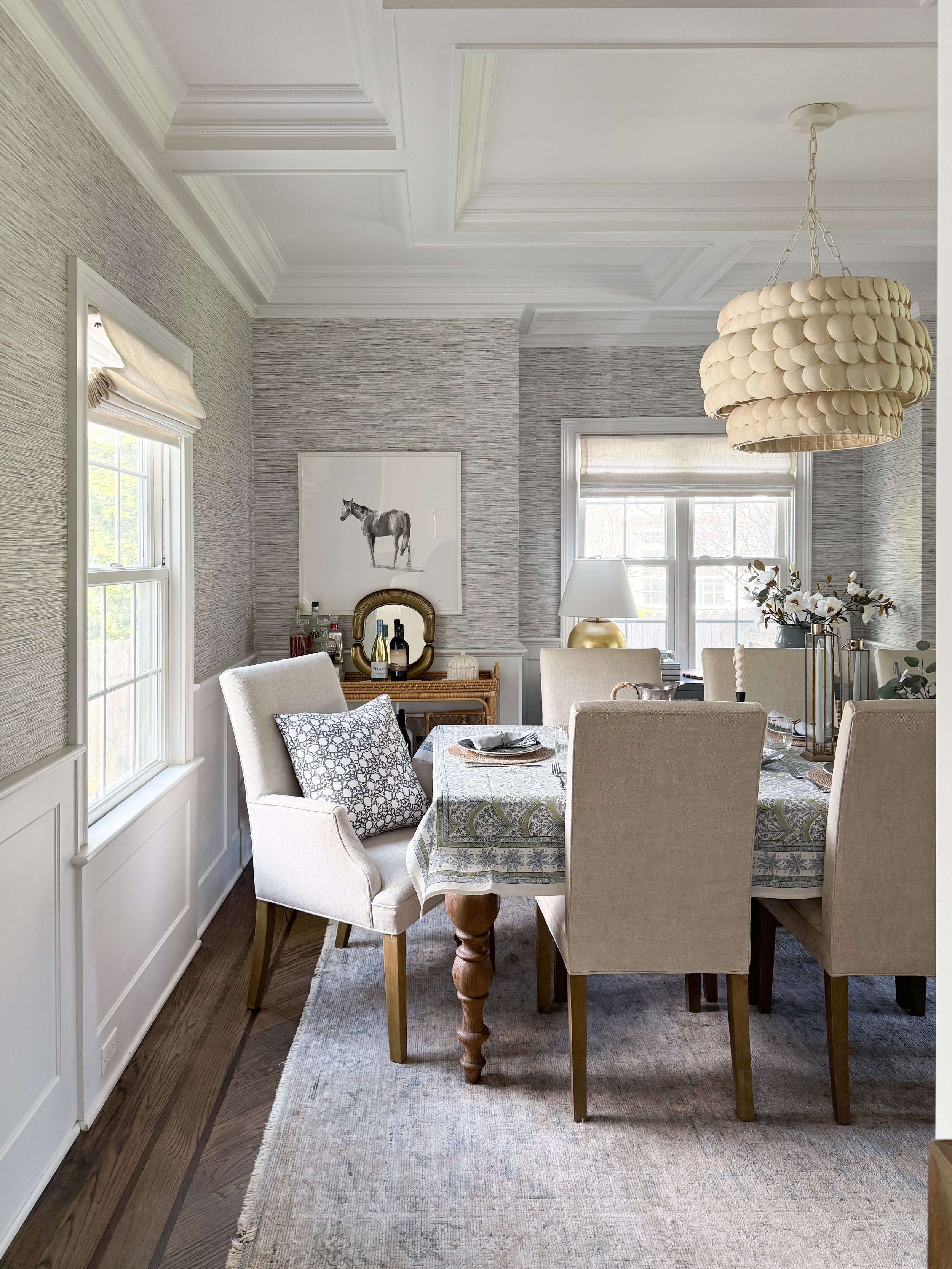 Neutral dining room featuring McGee and Co furniture, grasscloth wallpaper, upholstered dining chairs, and a wood table styled with a McGee and Co tablescape
