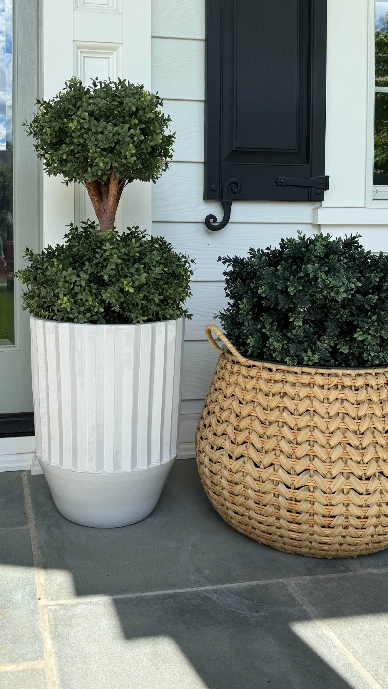 Amazon Prime Day outdoor decor deal featuring faux topiary plants displayed in white ceramic and woven porch planters.