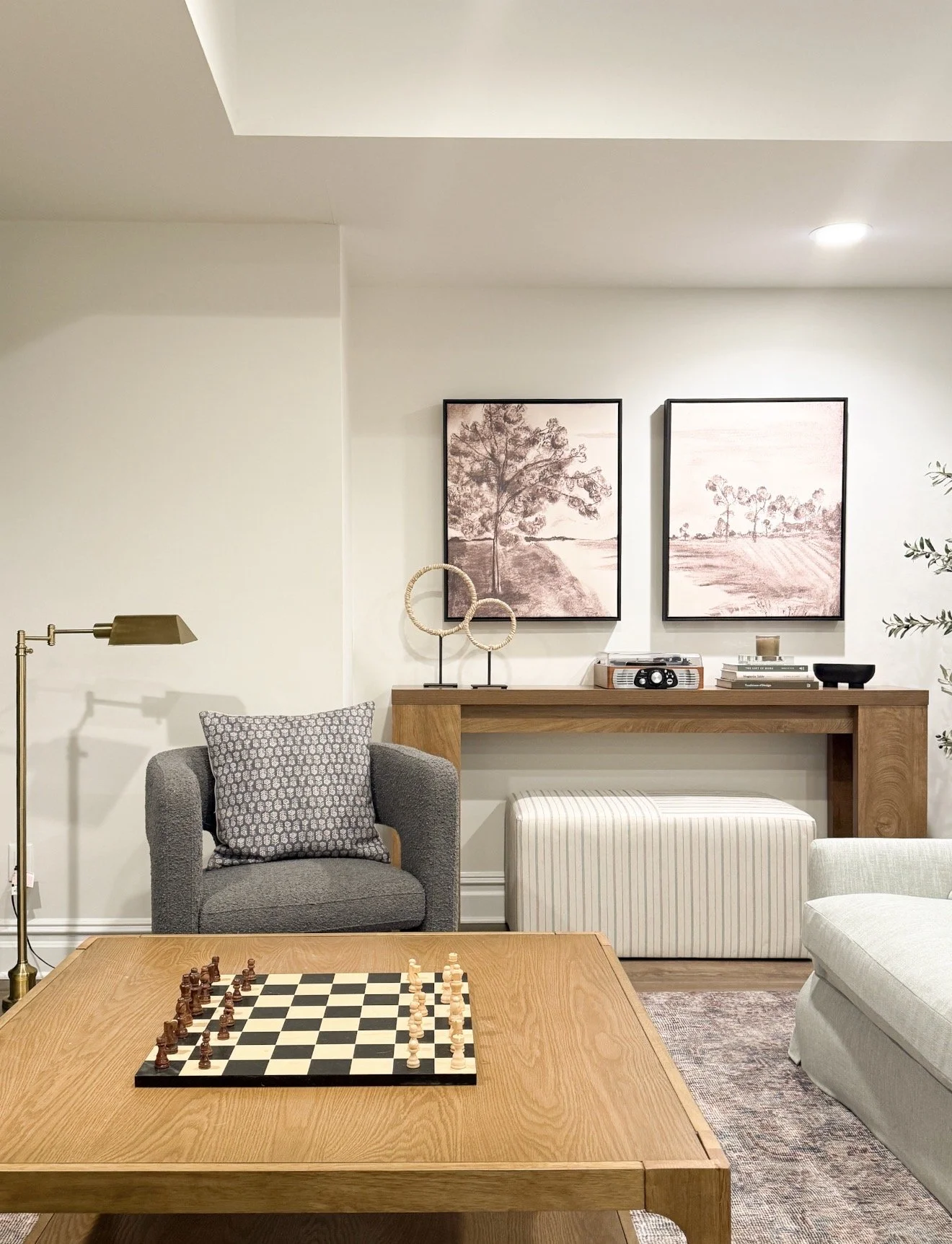 Affordable living room setup with sectional sofa, Walmart coffee table and neutral rug in basement lounge