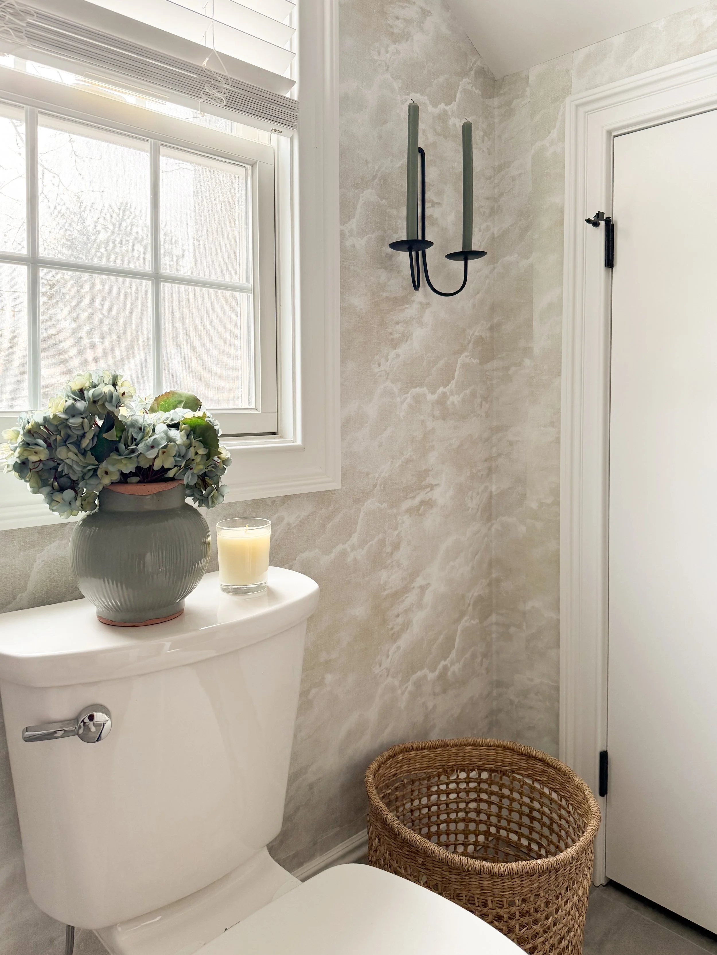 Amazon Prime Day bathroom decor find featuring black taper candle holders styled above a toilet with hydrangeas and woven basket accents.