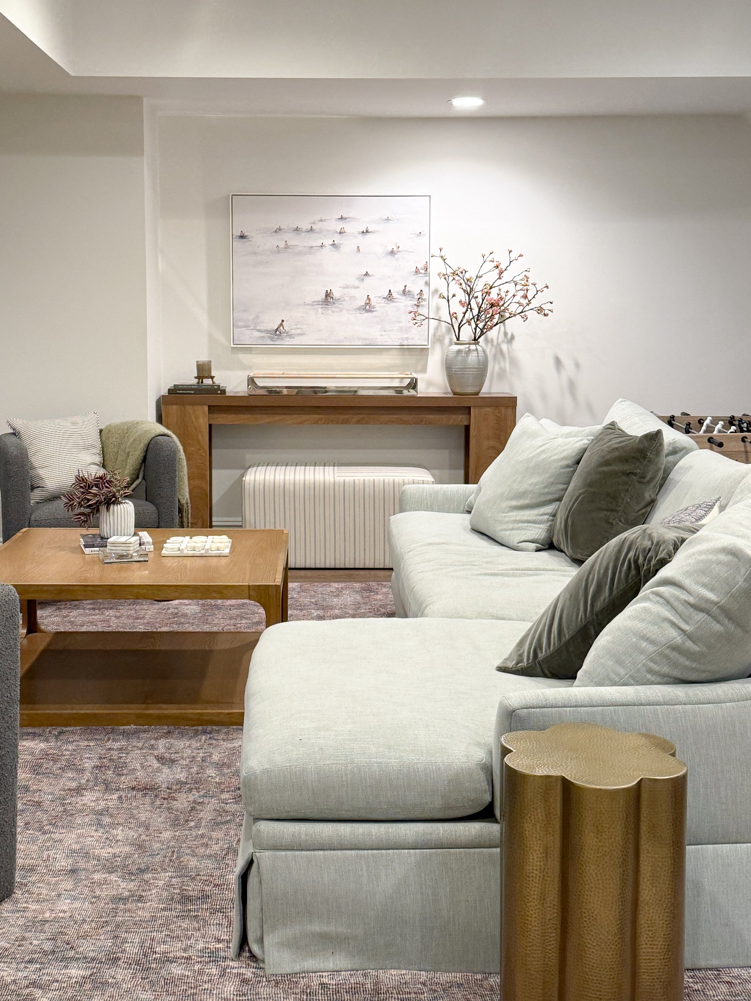 cozy basement seating area, oversized Minted artwork, modern basement design, neutral basement inspiration, soft coastal interiors, sectional sofa styling, warm wood tones, elevated family room decor, layered neutral textures, finished basement ideas