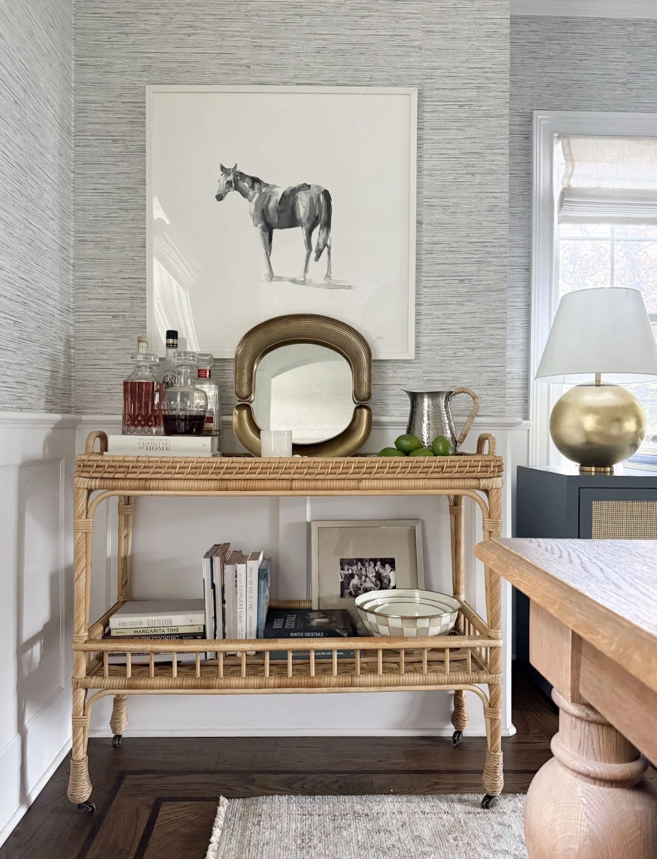 Serena & Lily South Seas bar cart styled with glassware, books, greenery, and decorative accents for home entertaining.