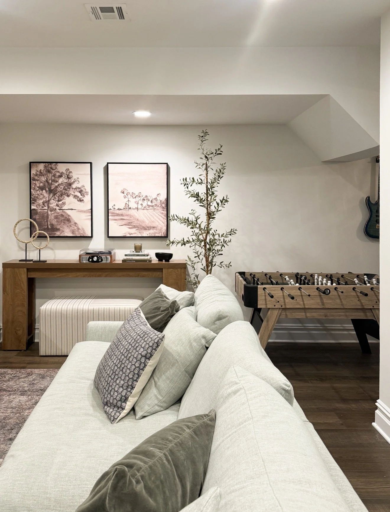 Basement entertainment area with foosball table, cozy seating and family friendly design