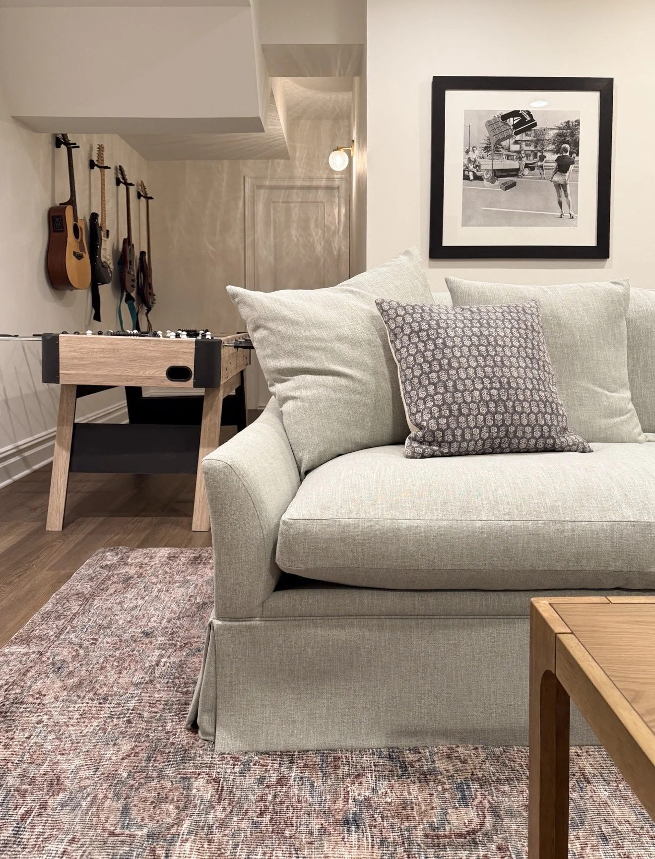 Basement entertainment area with foosball table, cozy seating and family friendly design