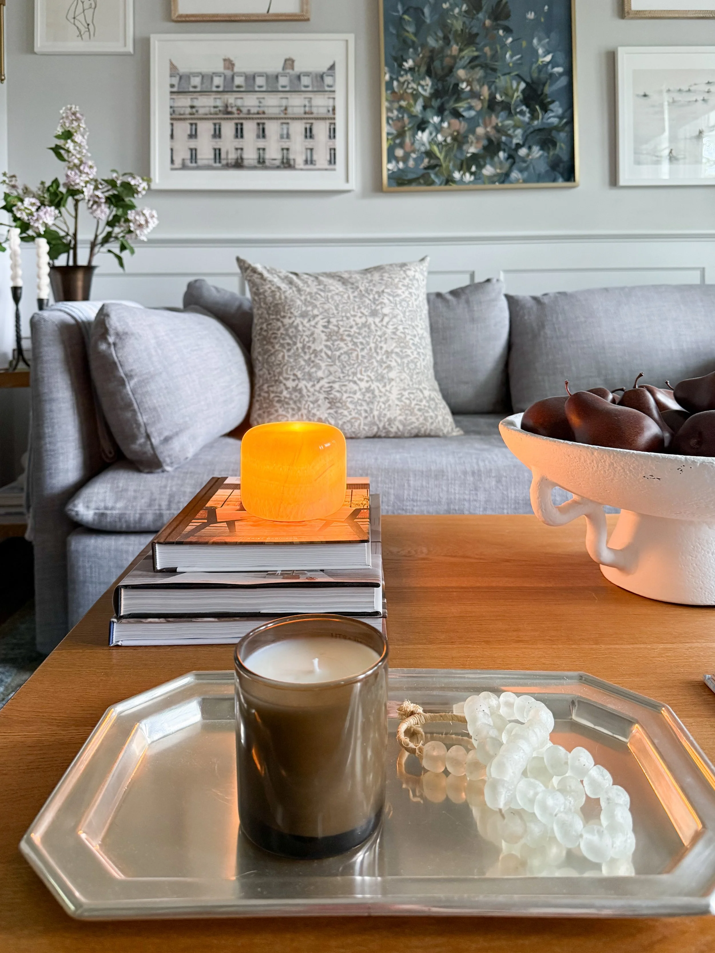 Elegant neutral dining room with marble table lamp, textured grasscloth wallpaper, layered lighting, wood dining table, and timeless coastal traditional decor