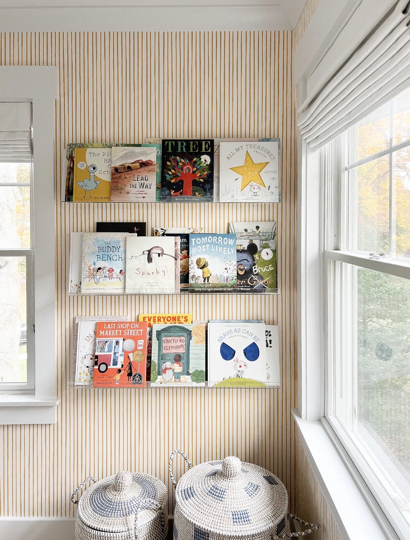 Blue and natural woven storage baskets displayed against orange and white striped wallpaper.