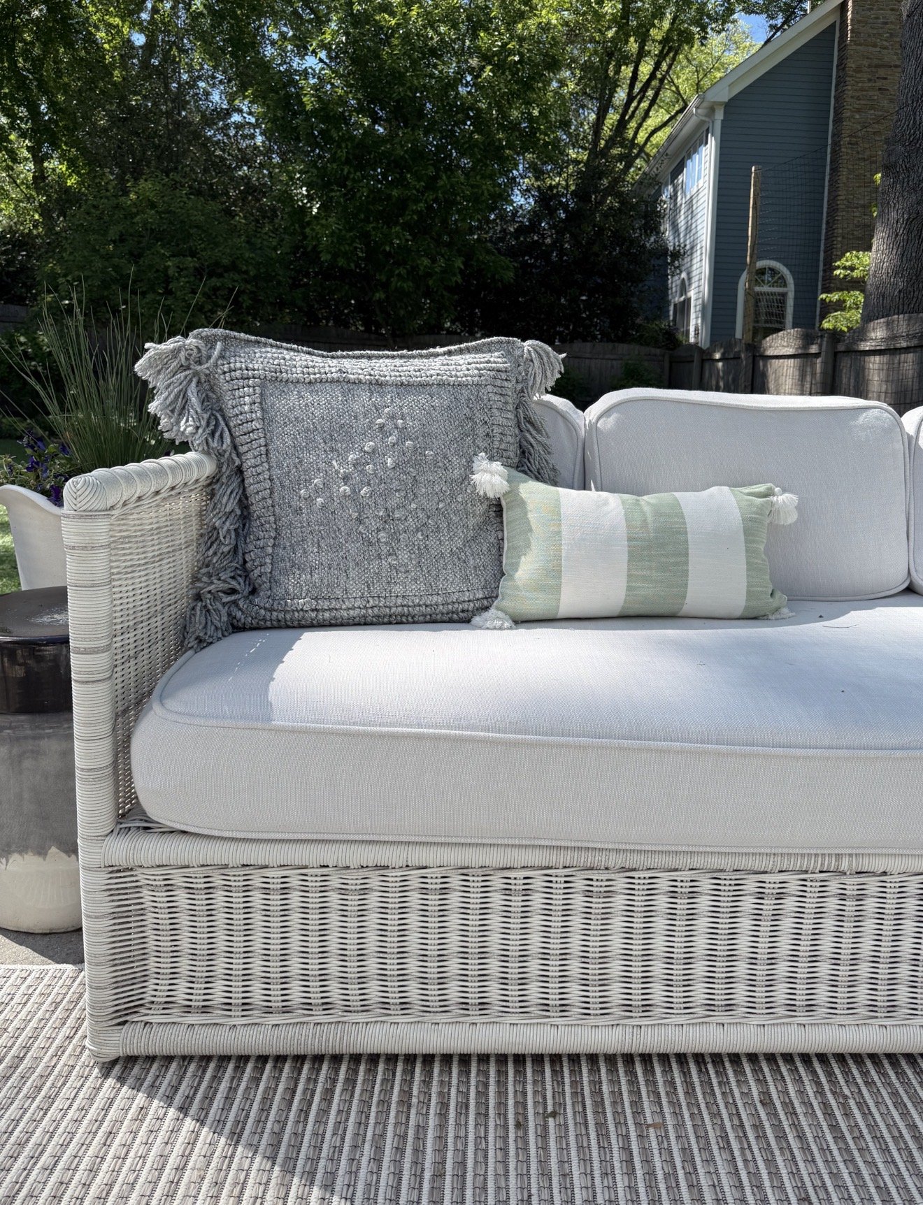 Outdoor sectional sofa from Serena & Lily with white cushions and green striped pillows on a sunny patio.