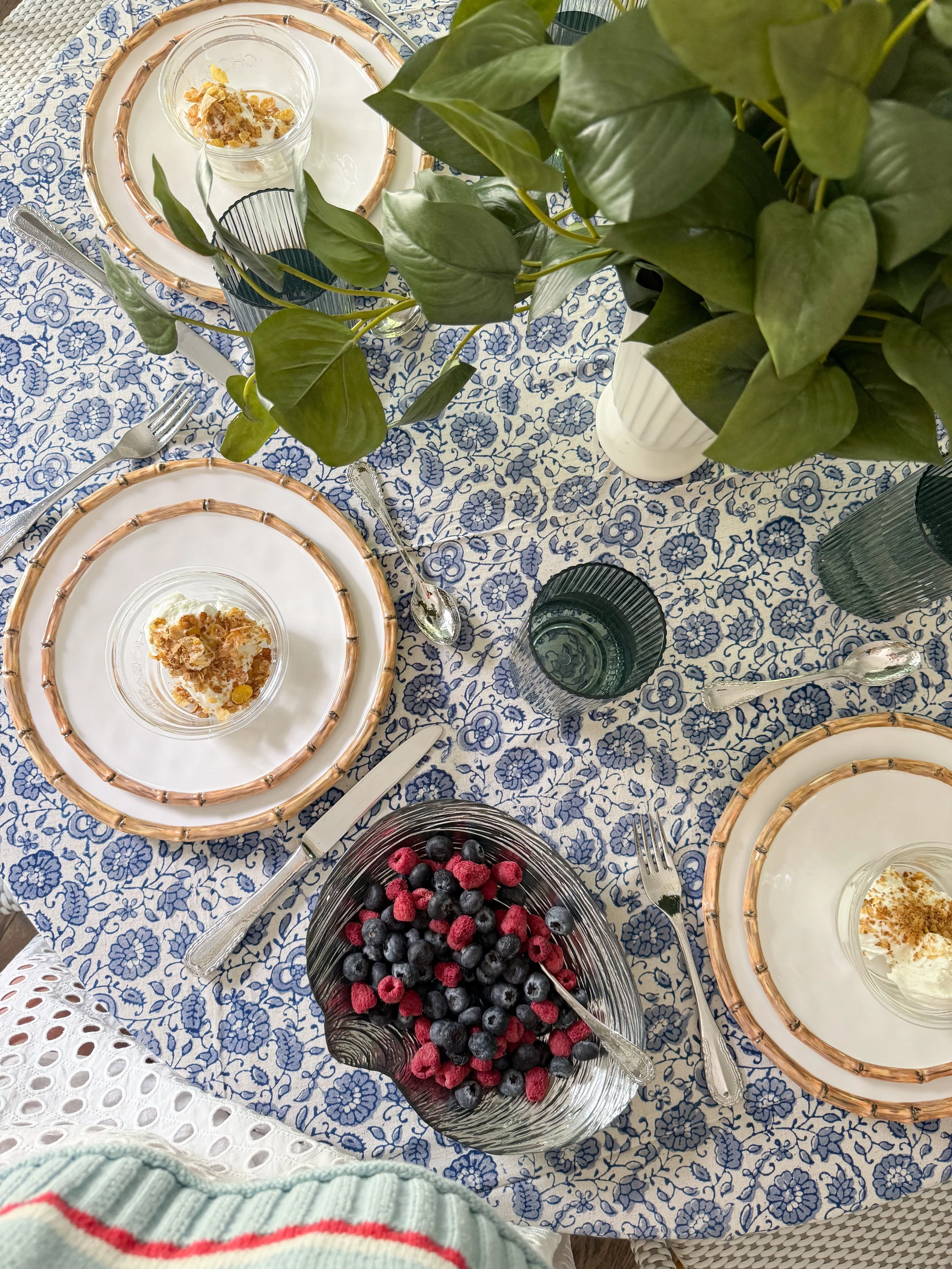 Elegant dining room featuring a McGee & Co inspired tablescape with blue and white tablecloth, layered entertaining pieces, candlelight decor, and timeless summer styling.
