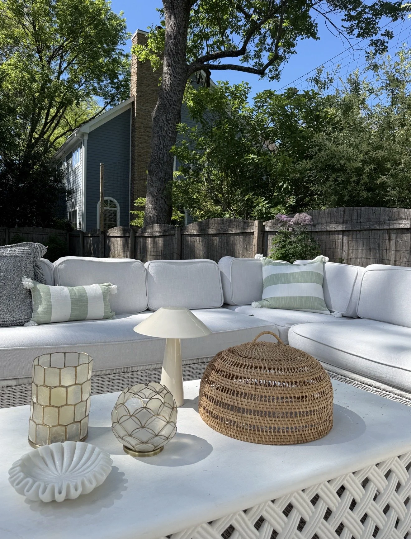 Outdoor sectional sofa from Serena & Lily with white cushions and green striped pillows on a sunny patio.
