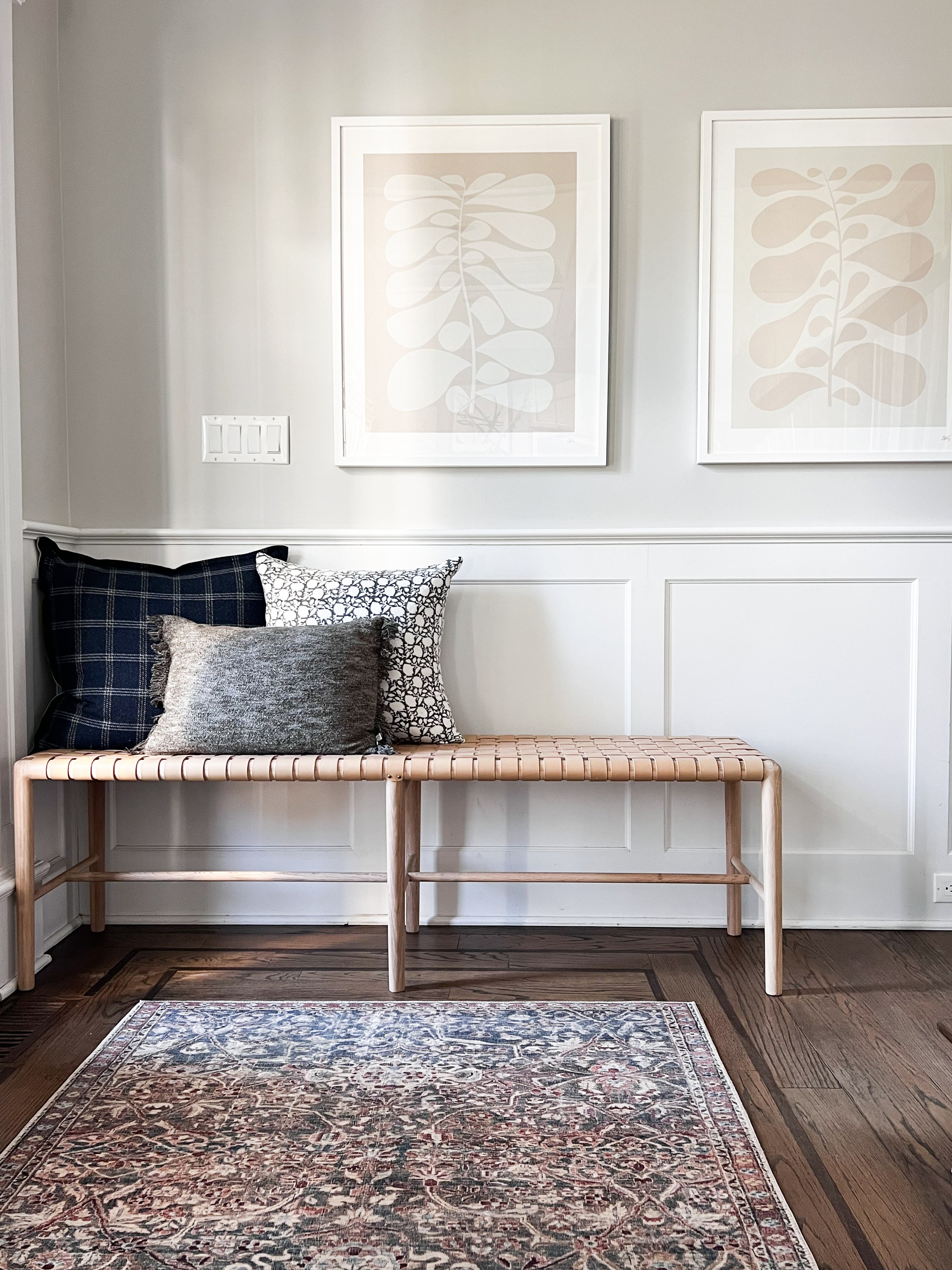 Welcoming entryway with a vintage inspired runner rug, woven leather bench, wood console table, and neutral décor.