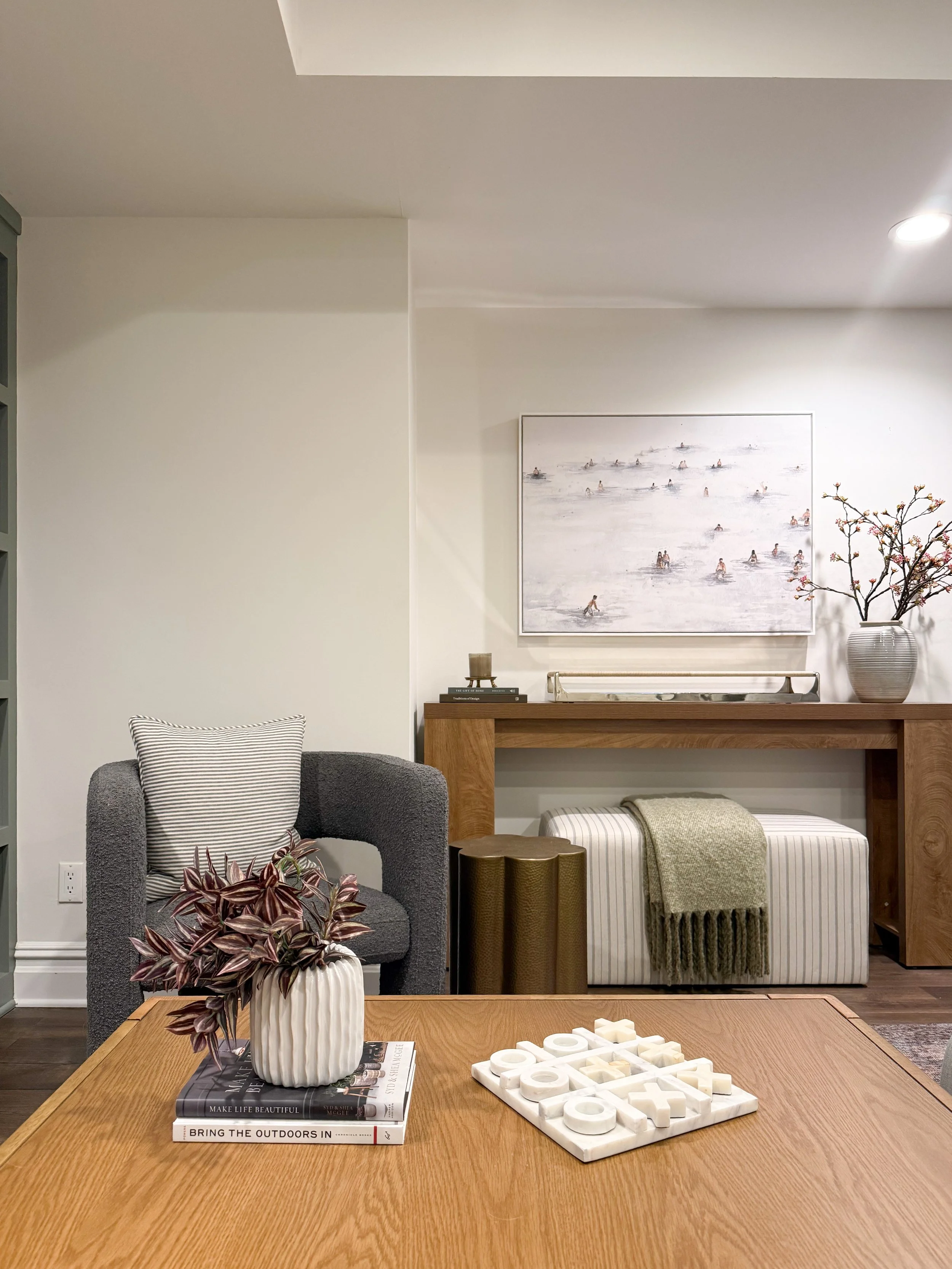 Cozy media room seating area with an upholstered accent chair, side table, and layered home décor.