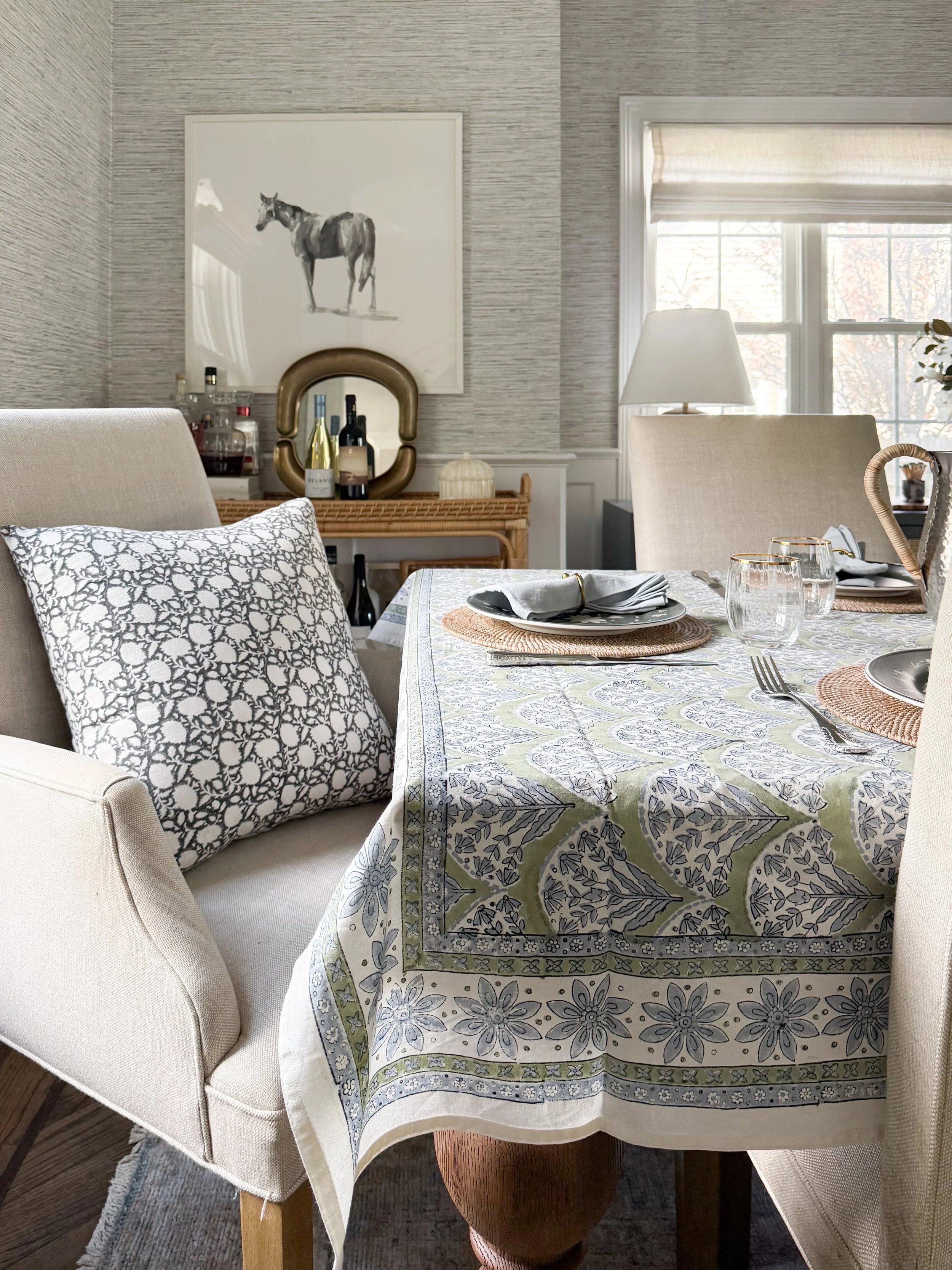McGee and Co blue and green block print tablecloth styled on a wood dining table with neutral upholstered chairs for a spring tablescape