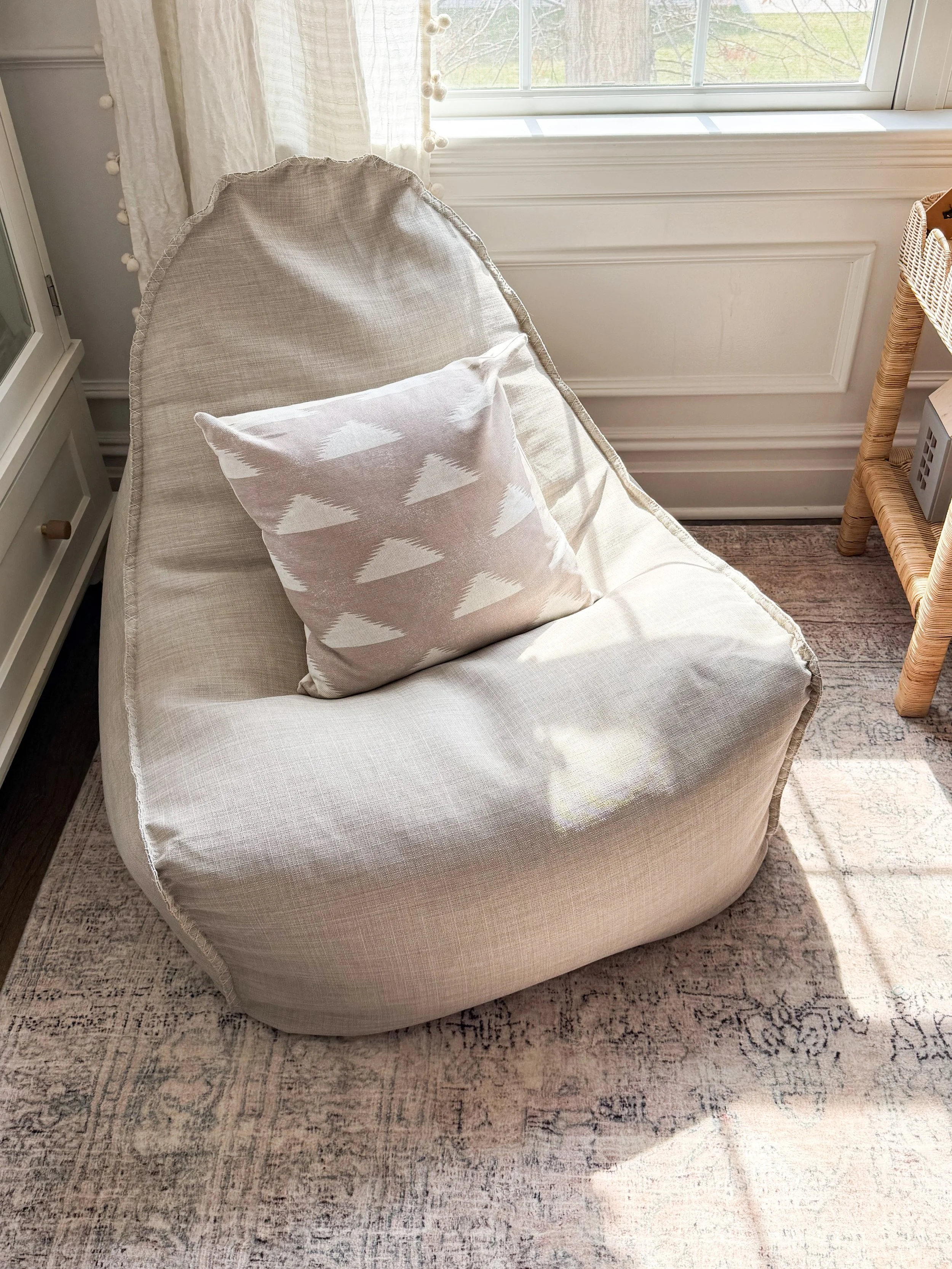 Inviting kids' room reading nook featuring layered pillows, cozy seating, and warm, family-friendly design.