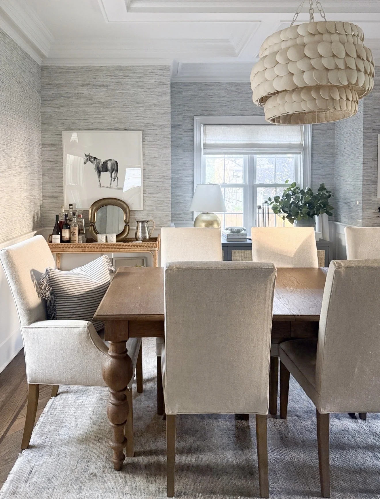 Serena & Lily Pescadero Chandelier above a dining table in a bright dining room with woven textures and classic coastal style.