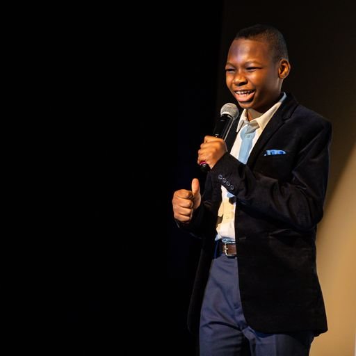 Image of a young male performer singing on stage at The Danny Awards.