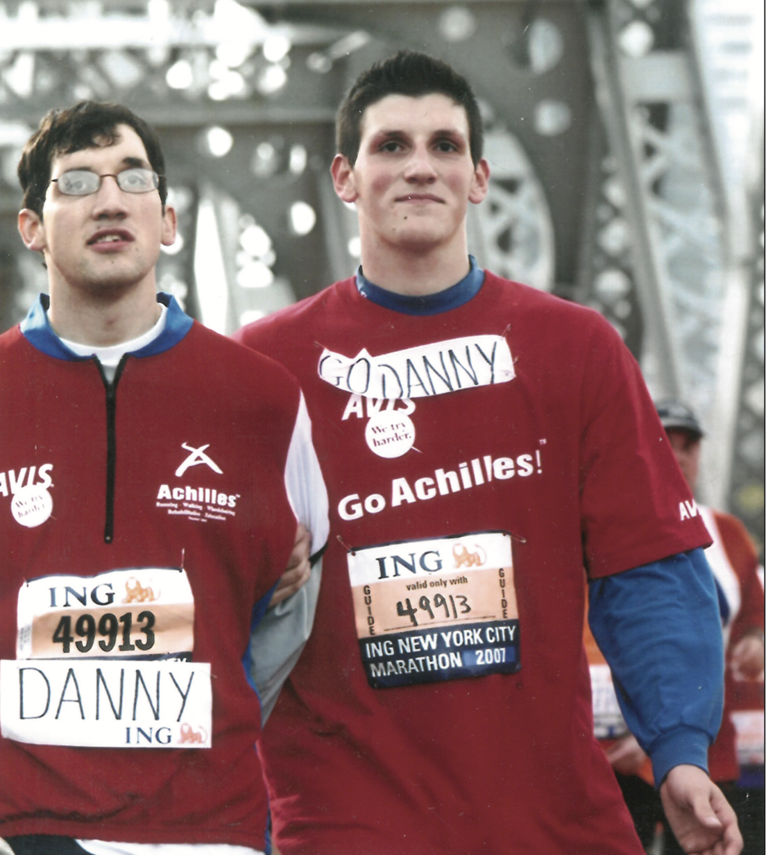 Image of Daniel and his brother Michael walking across a bridge, wearing NYC Marathon shirts. 