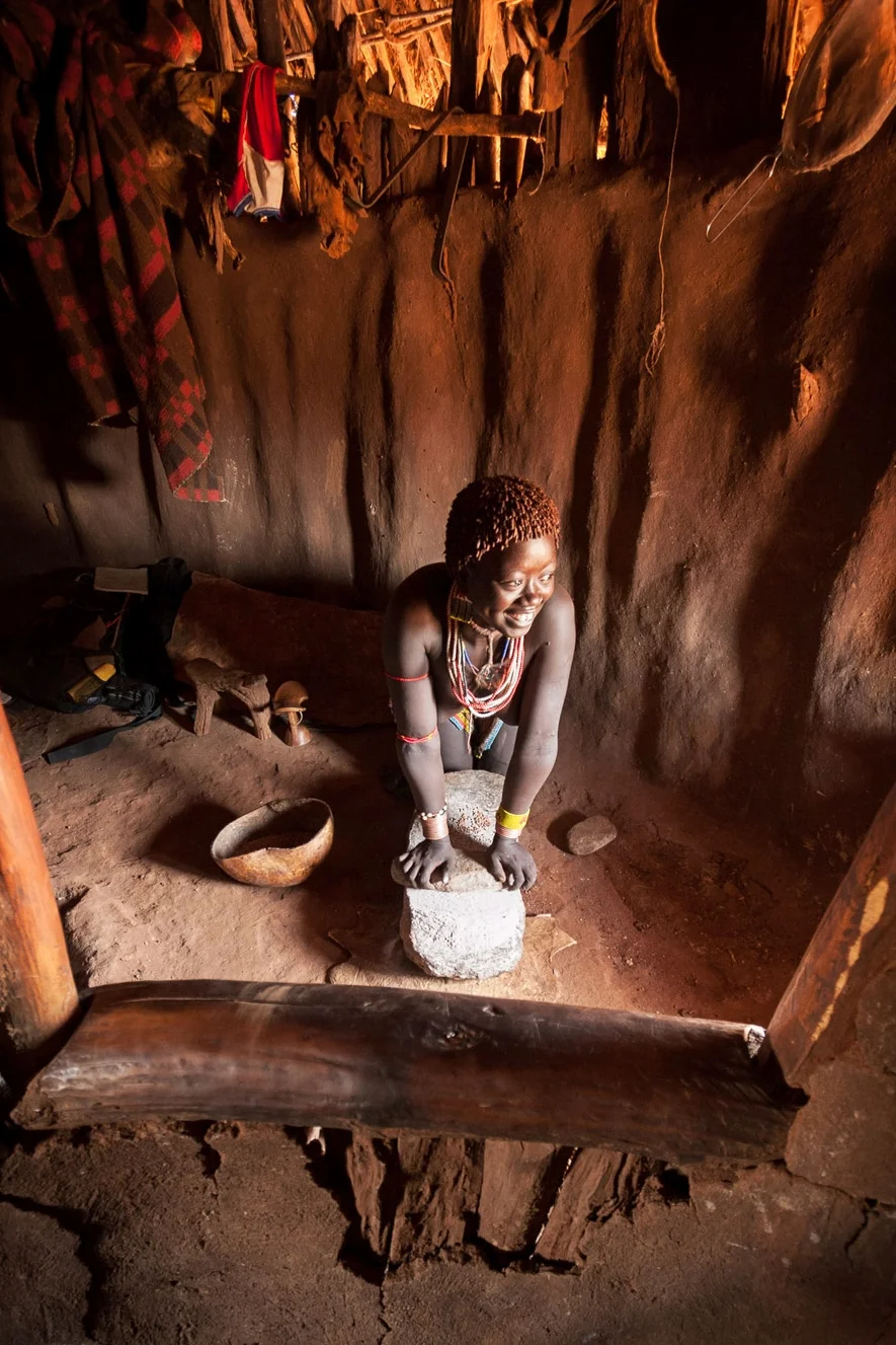 Grinding millet; Omo Valley, Ethiopia