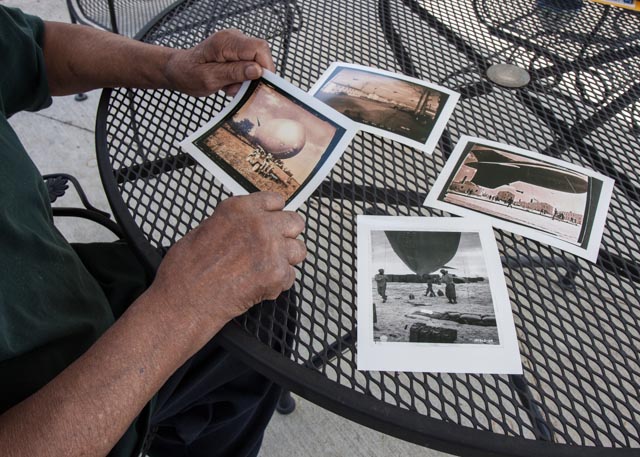 Sam Mattison flips through photos of the barrage balloons that he flew in Tennessee, Britain and on Omaha Beach. Photo: Linda Hervieux
