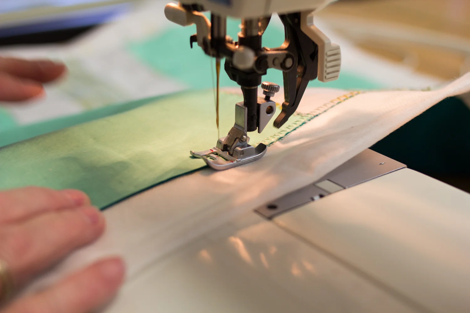 Stitching down the edge of the fabric.