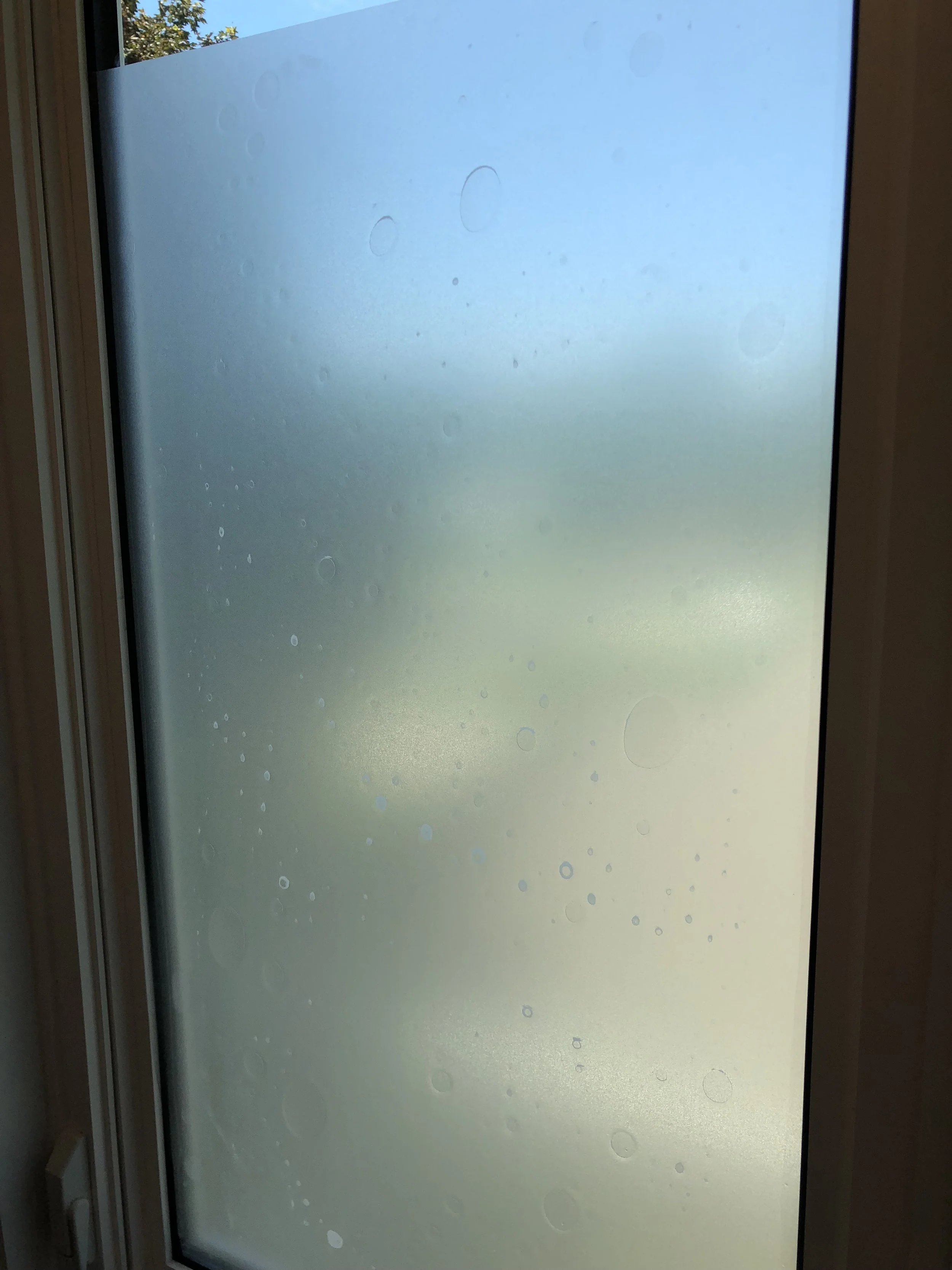Window with air bubbles under privacy film
