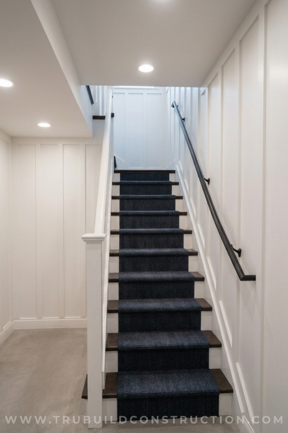 Recessed can lights installed in a low basement stairway ceiling