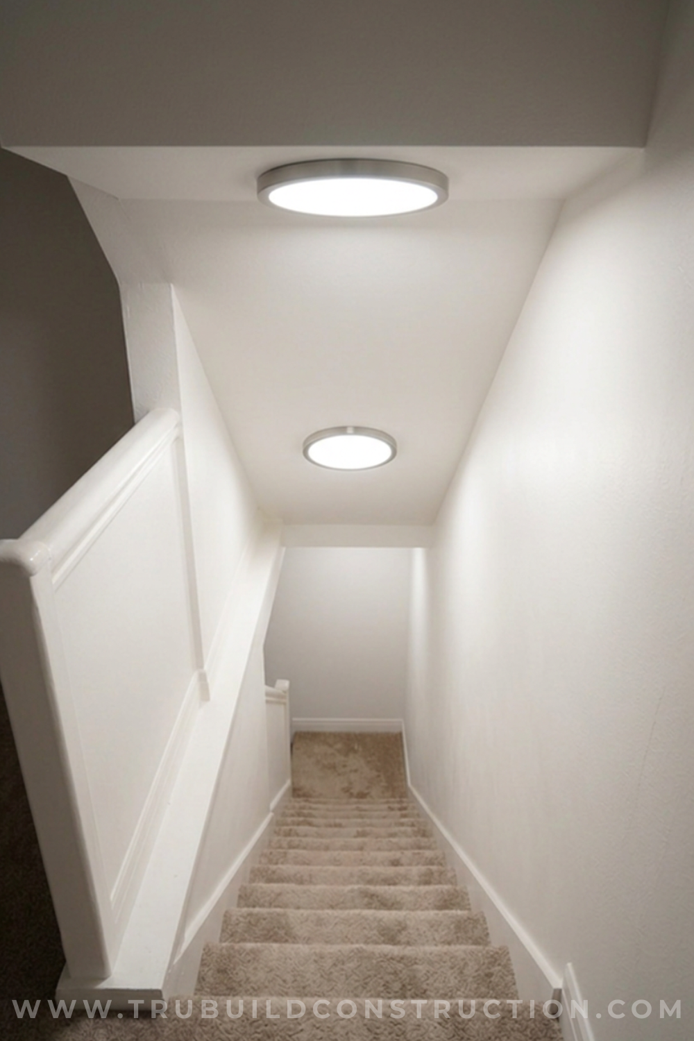 Low-profile flush mount ceiling light above a basement stairway