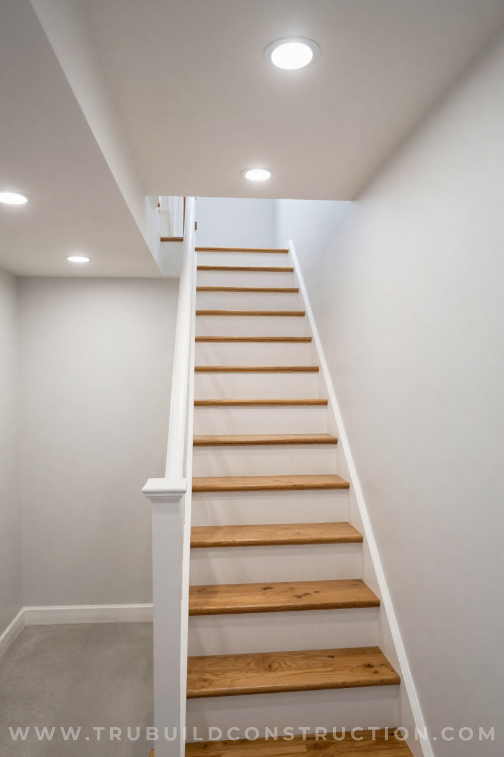 Recessed can lights installed in a low basement stairway ceiling