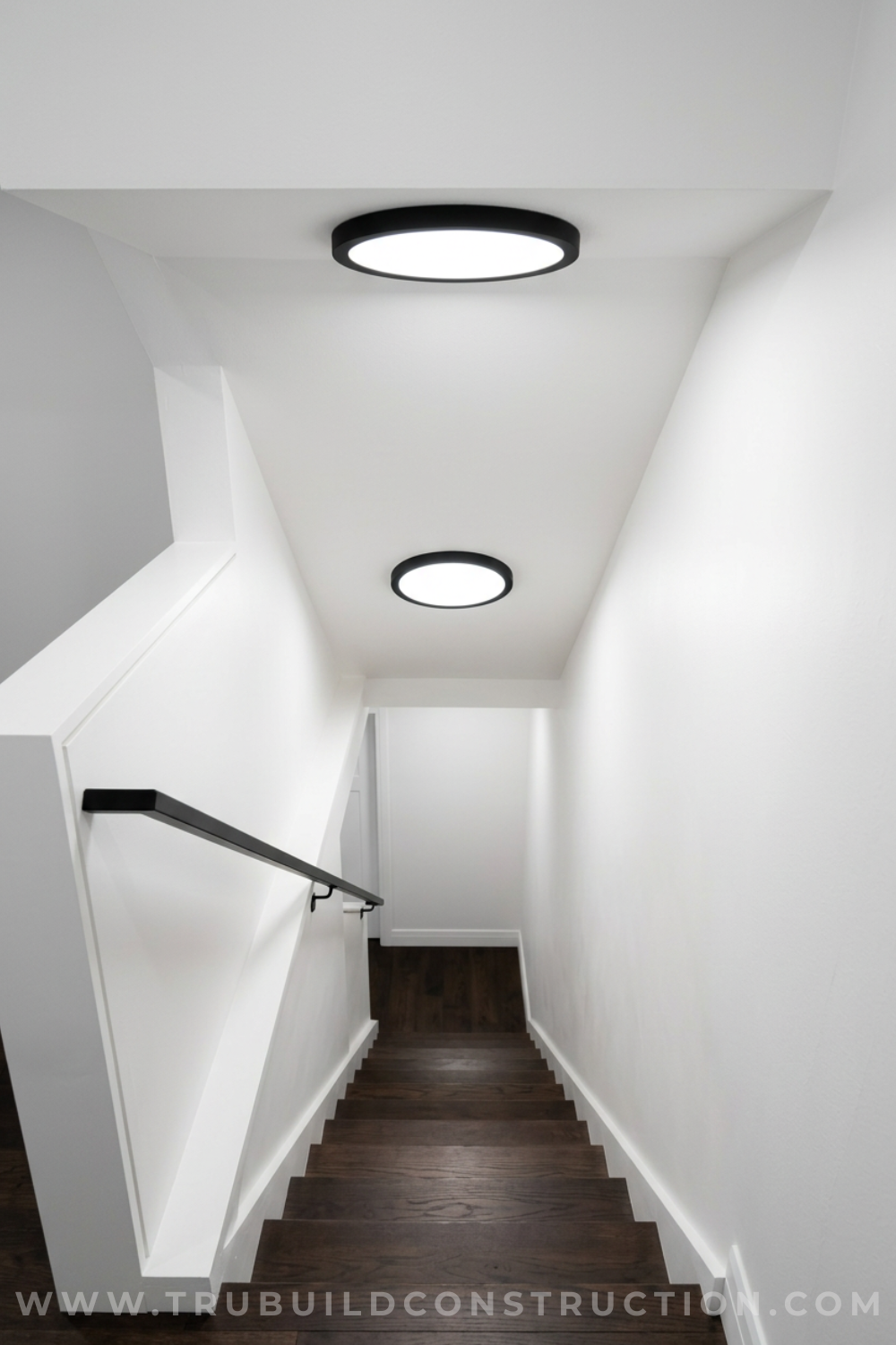 Low-profile flush mount ceiling light above a basement stairway