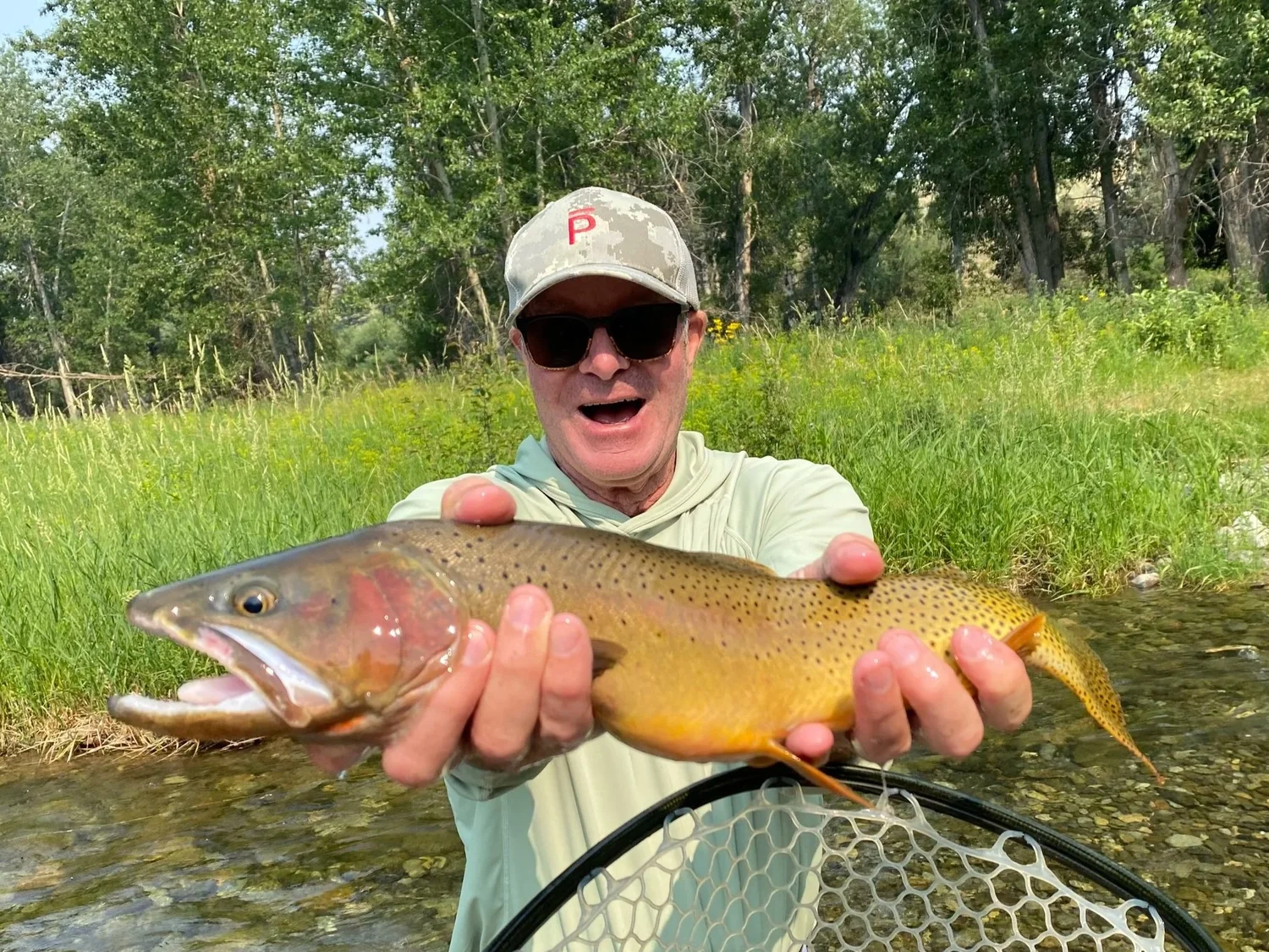 Guests enjoy a scenic wooden boat tour with mountain views on the Yellowstone River in Paradise Valley Montana.