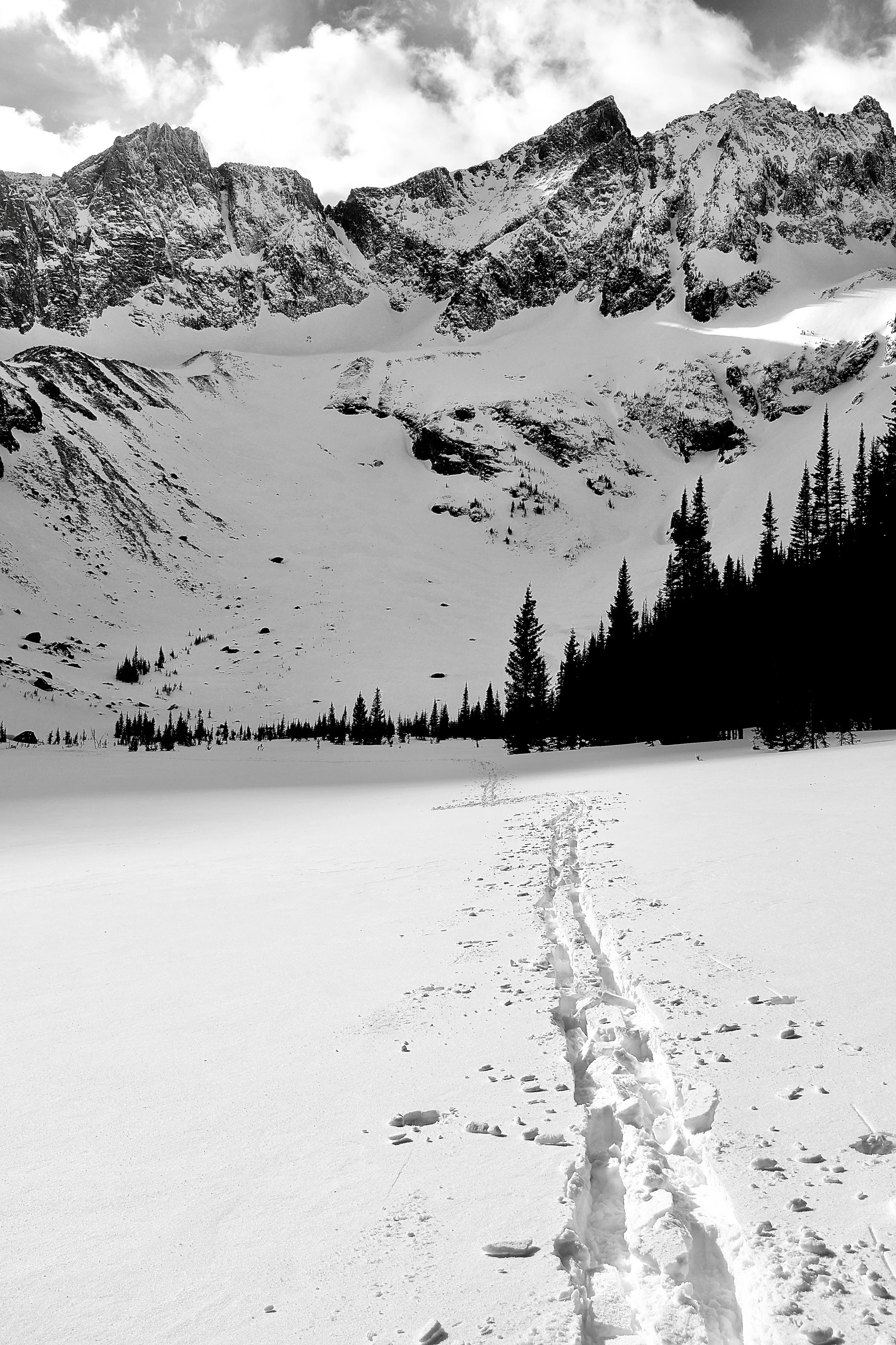 Winter snowpack filling a high alpine basin in Montana’s Crazy Mountains, accessed by ski track