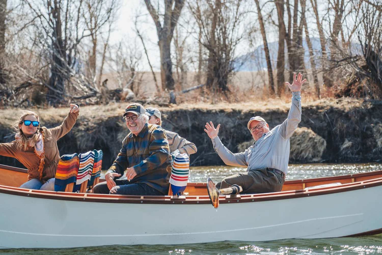 Guests enjoying a scenic wooden boat float on the Yellowstone River in Paradise Valley Montana.