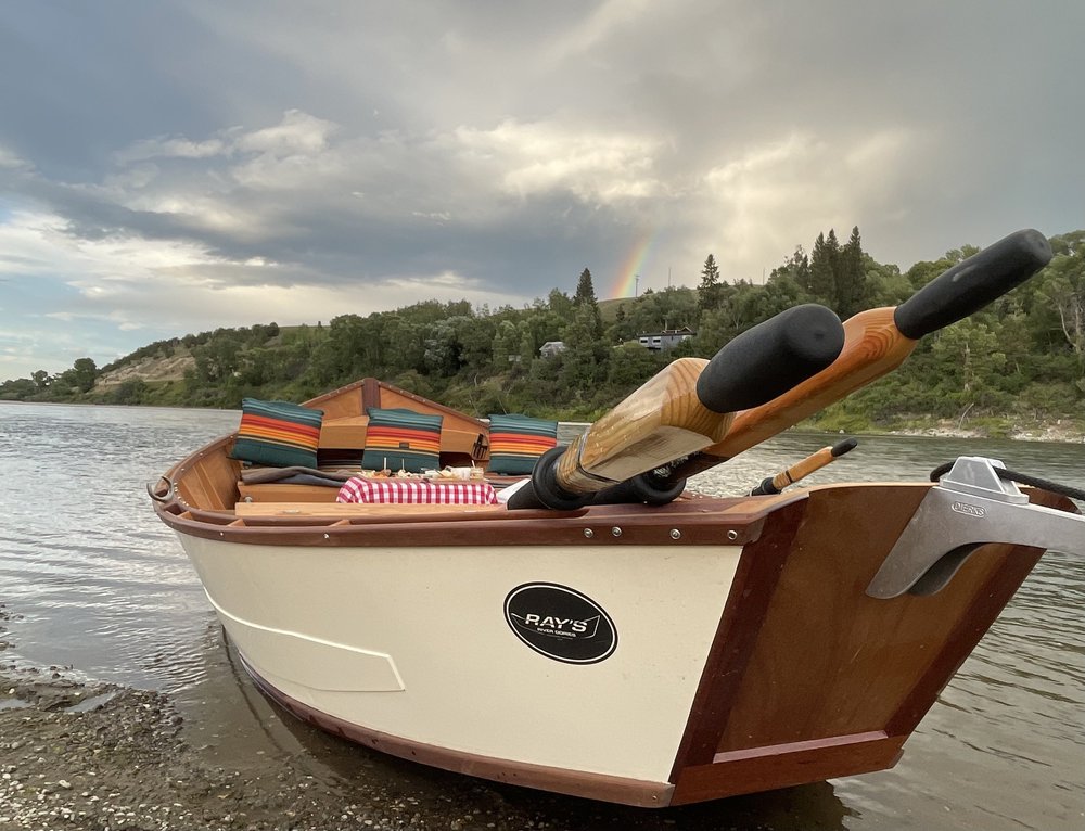 Classic wooden Ray's River Dory on the Yellowstone River during a private scenic boat tour in Montana.