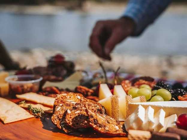 Scenic Yellowstone River boat tour in Paradise Valley with guests enjoying mountain views from a wooden dory.