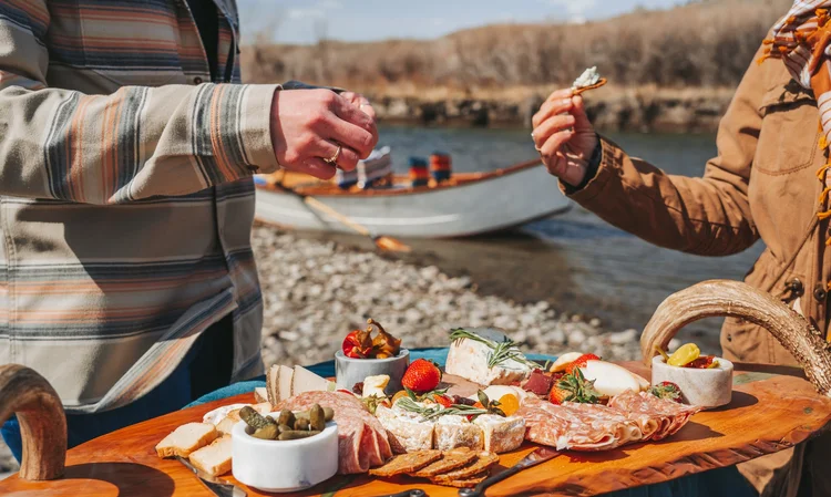 Charcuterie board from Ranchmade Charcuterie on a scenic wooden boat float on the Yellowstone River