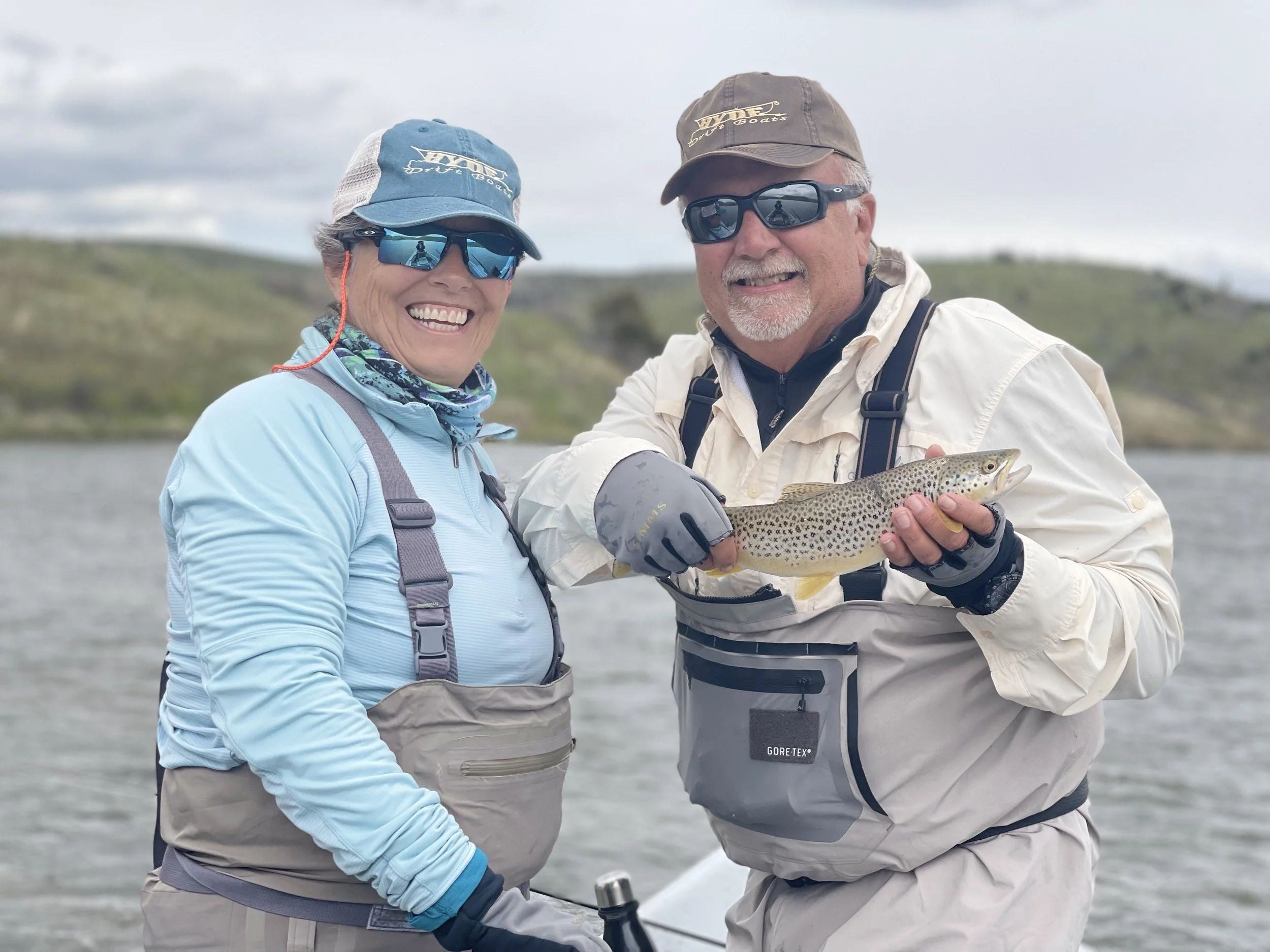 Two anglers with a trout while winter fly fishing on the Lower Madison River near Bozeman, Montana, on a guided trip.