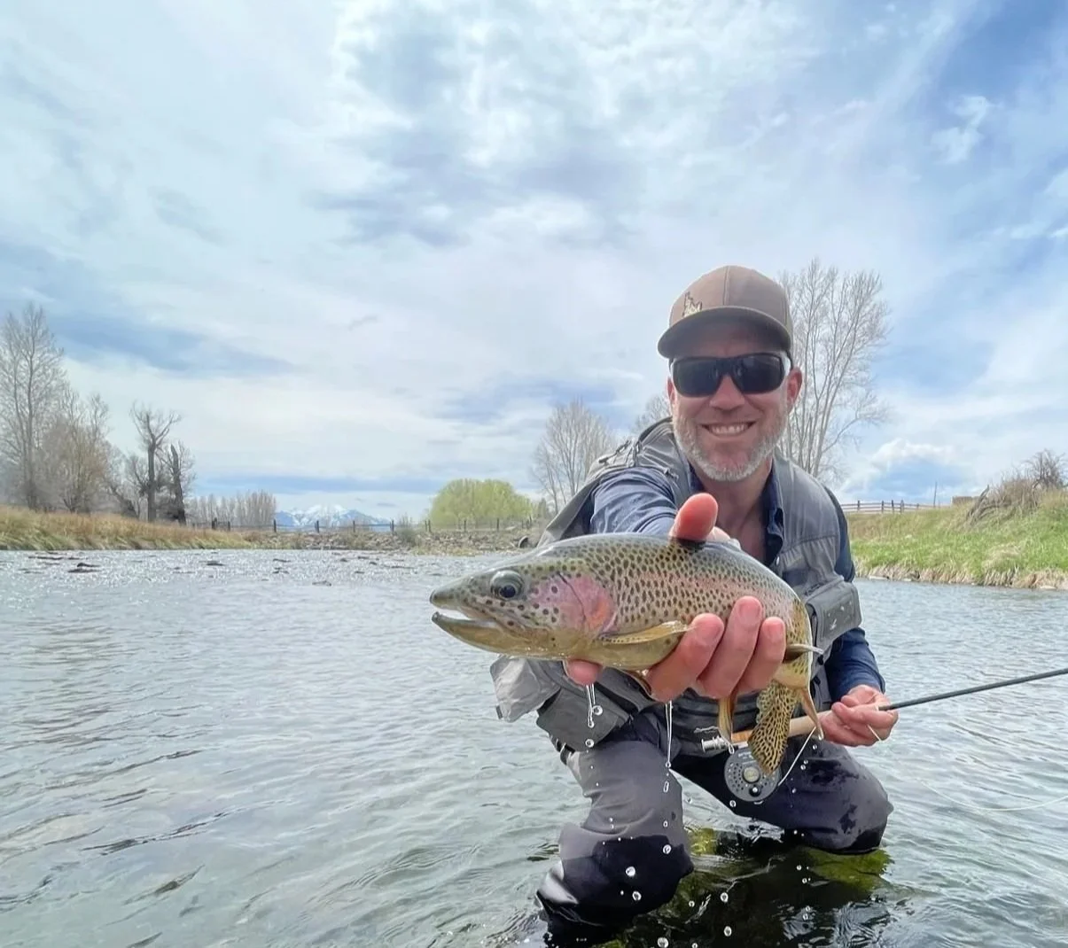 Montana Trout Camp instructor Chris Gerono holding a rainbow trout.