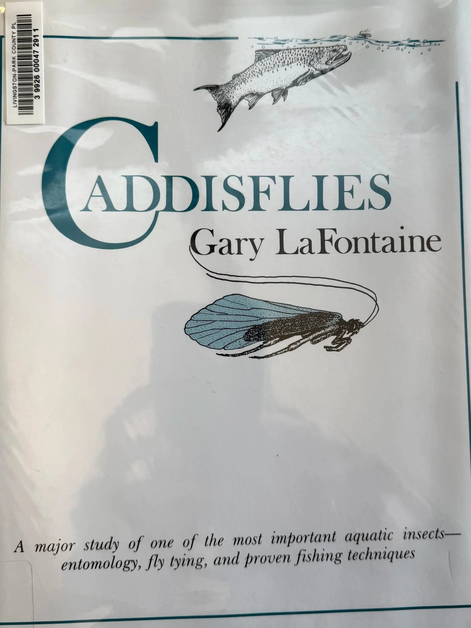 Cover of Caddisflies by Gary LaFontaine checked out from Livingston Park County Library, showing an illustrated caddisfly adult with tent wings and a trout rising to the surface — the foundational book on caddis entomology for fly fishing and the origin of the Sparkle Pupa pattern