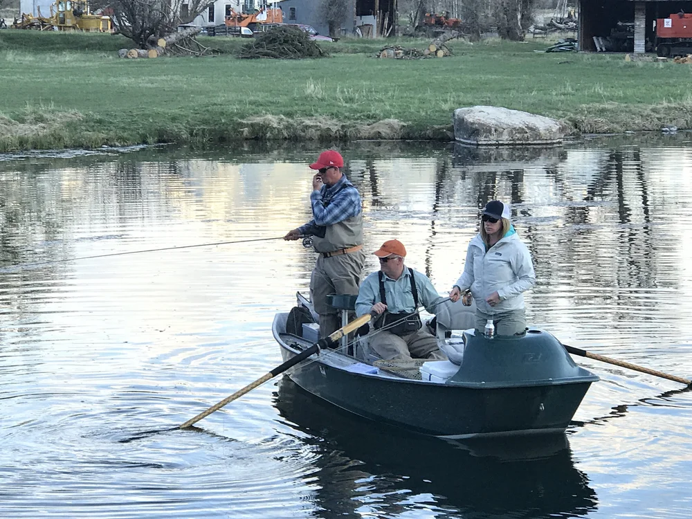 Paradise Valley private trout lake near Livingston with mountains reflected in calm water at sunset.