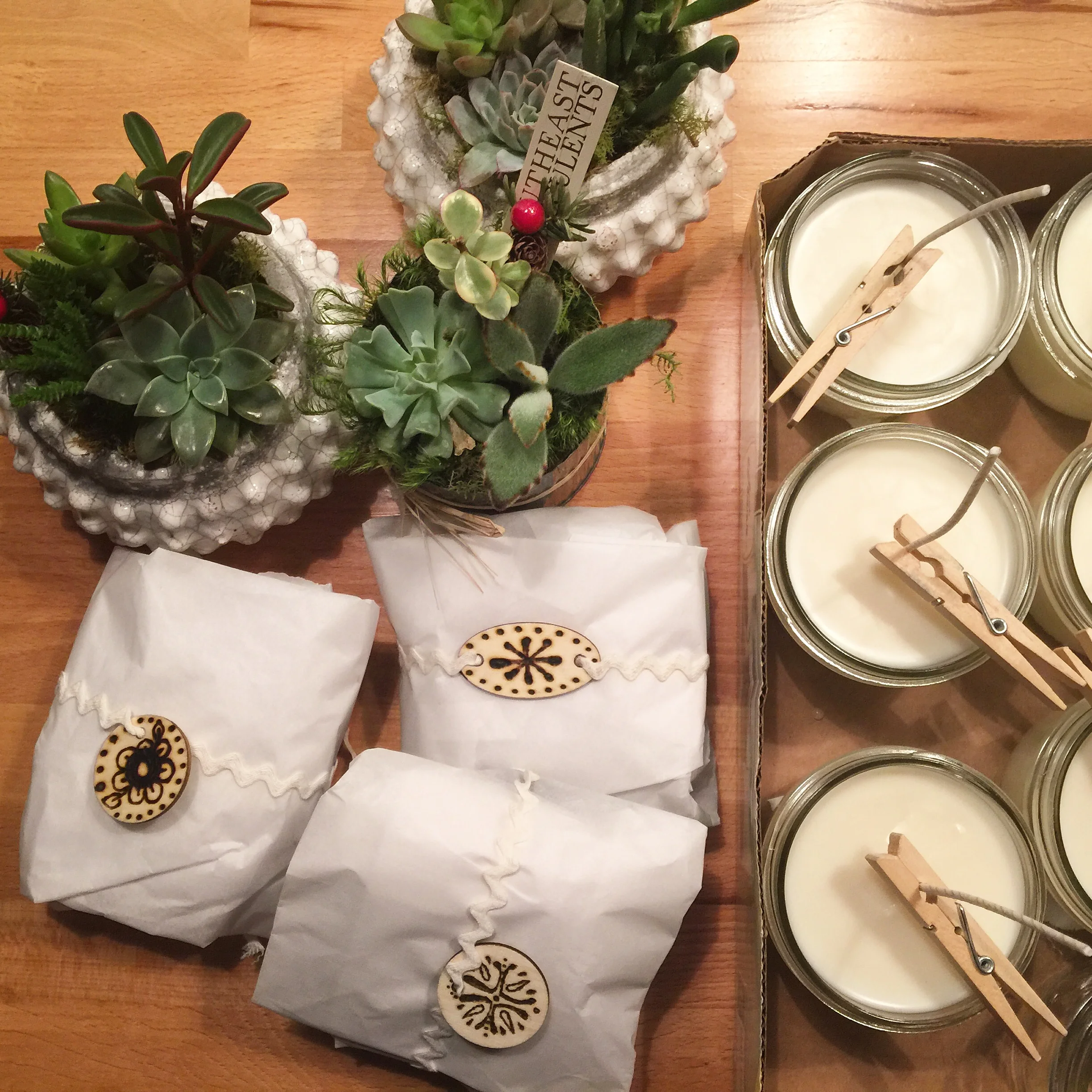 Succulents from a local spot, homemade cookies with woodburned tags, and homemade soy candles for teacher's gifts.