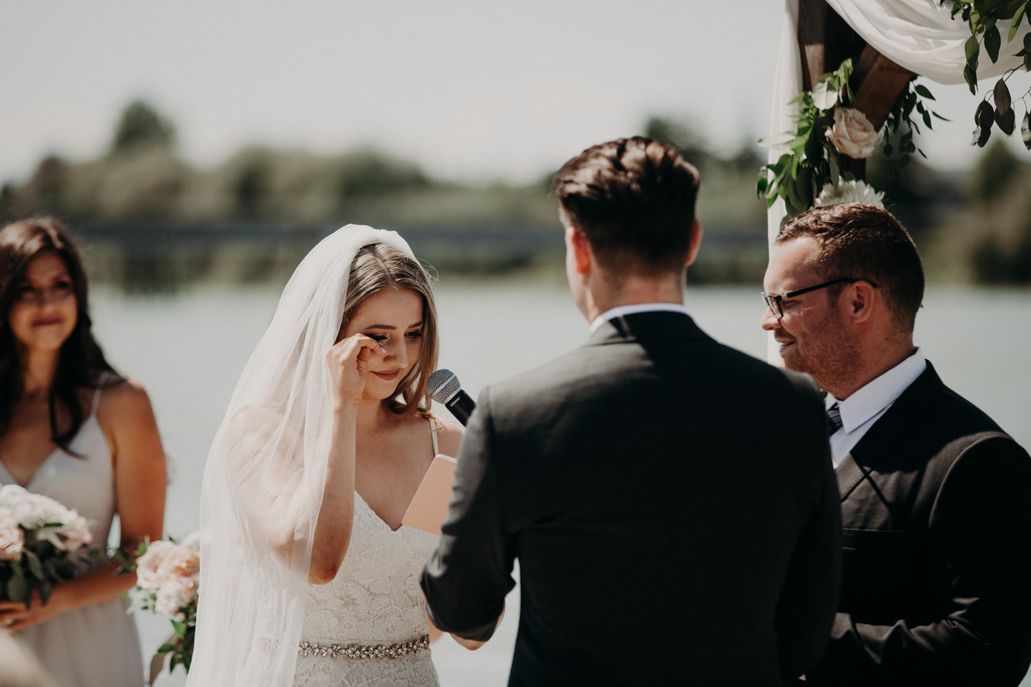 The bride wipes away a tear during the ceremony at the UBC Boathouse in Richmond, BC. 