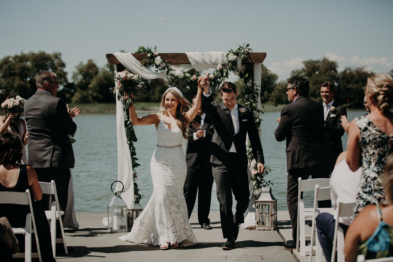 The bride and groom celebrate as they exit their ceremony at the UBC boathouse in Richmond, BC. 