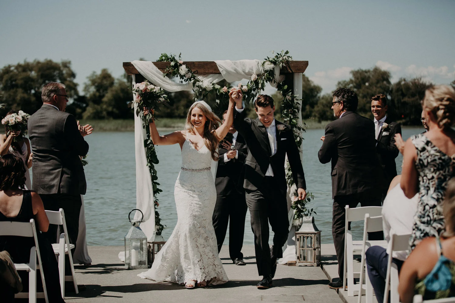 The bride and groom celebrate as they exit their ceremony at the UBC boathouse in Richmond, BC.