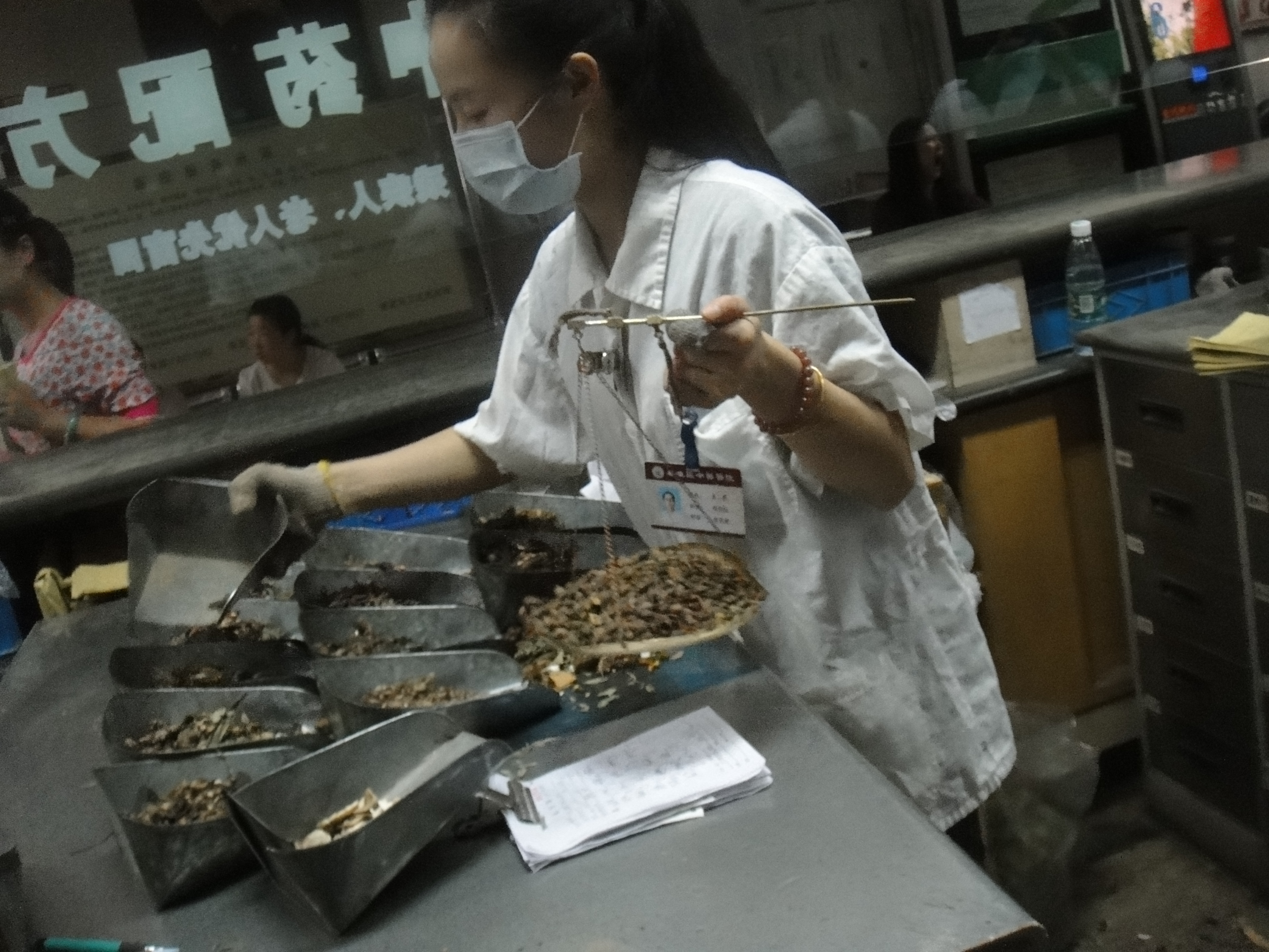 A woman weighs and dispenses Chinese herbs at Qin Huai Hospital in Nanjing, China.