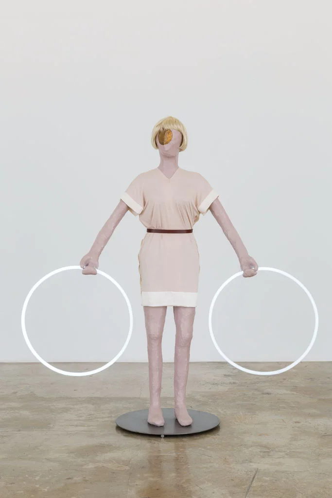 Mai-Thu Perret with Ligia Dias, Apocalypse Ballet (2 White Rings), 2006, steel, wire, papier-mâché, emulsion paint, varnish, gouache, wig, fluorescent tubes, viscose dress and leather belt (designed and made by Ligia Dias), 175 x 165 x 65 cm. Rubell Family Collection