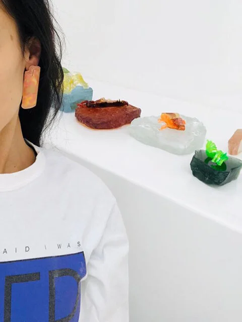  Ligia Dias, CESAR (lighter), 2017/19, earring, resin, metal leaf. Courtesy Ligia Dias   Shop CESAR   / Isabelle Cornaro, Orgon Door IV (no.5, green frame), 2014, colored elastomer, lacquered steel, 44 x 86 x 7 cm. Private collection Geneva / Florence Tétier, plastic jewelry. Courtesy Florence Tétier / Dawn Bendick, Machu Pichu, glass stones. Courtesy Dawn Bendick. Photo Jeanne-Salomé Rochat 