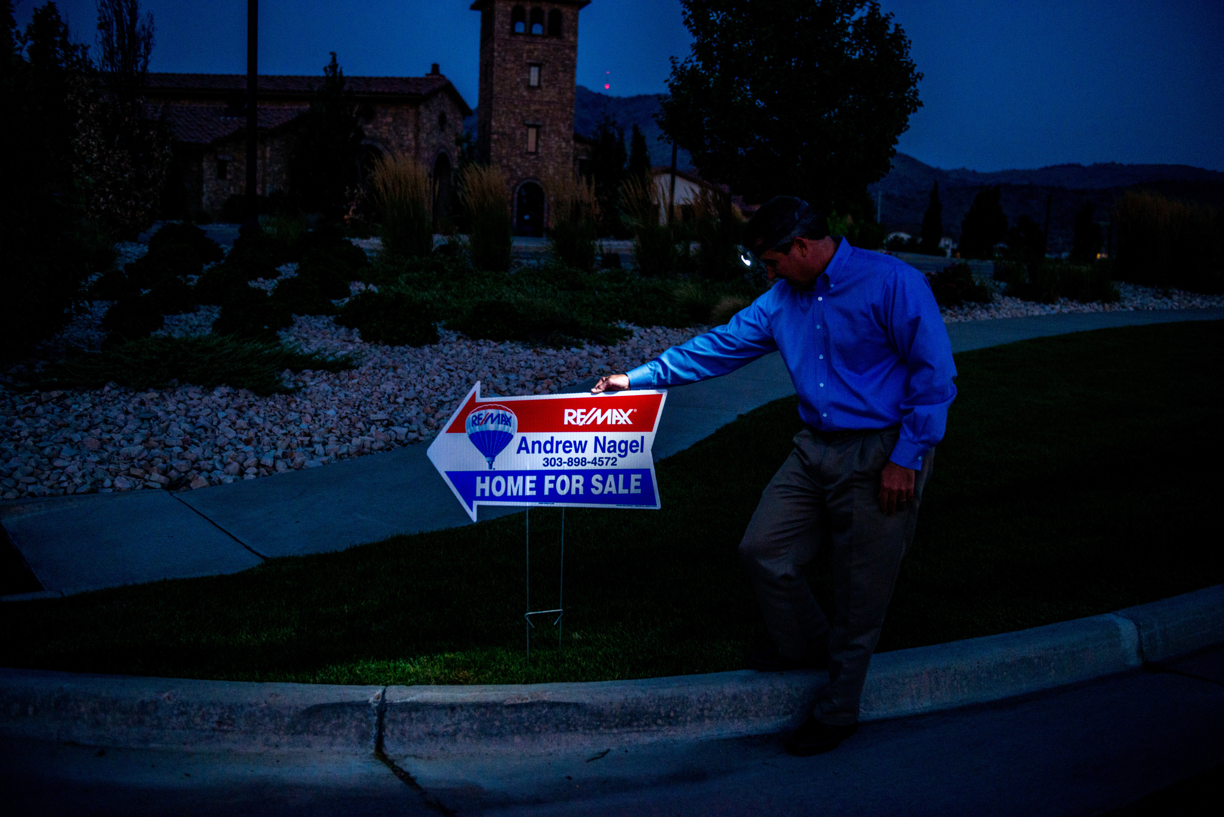 Andrew Nagel Realtor putting out signs in the dark.