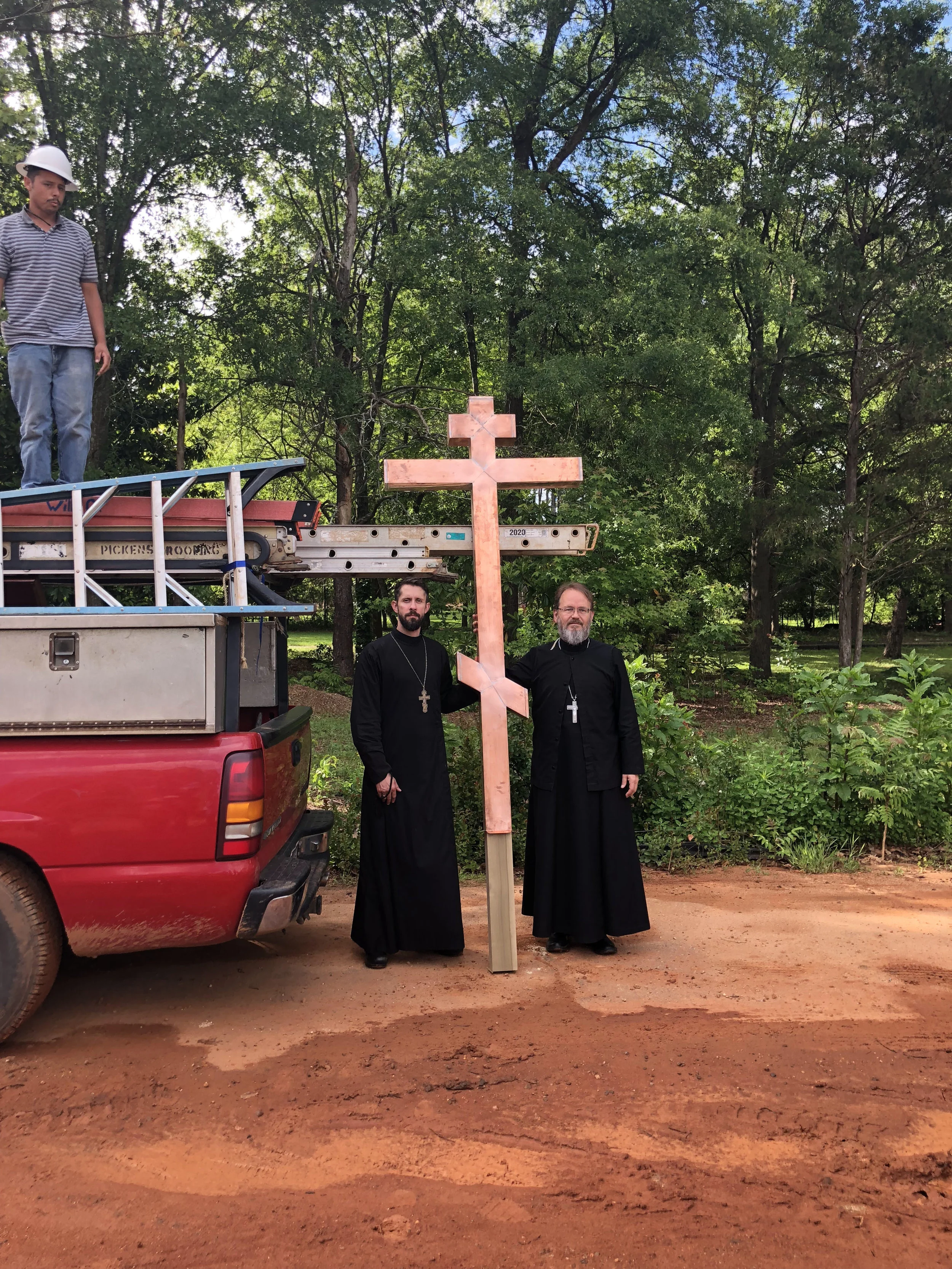 Fr. Marcus and Fr. David with the cross before its placement on the dome.