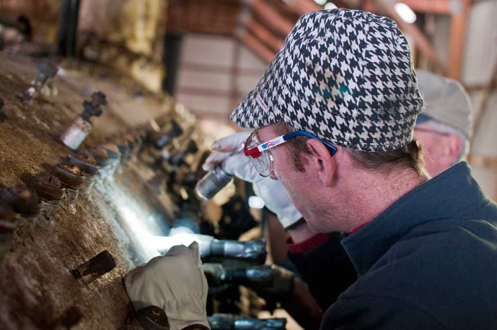 Shane Meador (foreground) and Joe Bratcher (background) look over the condition of the firebox wrapper sheet in the vicinity of boiler studs.