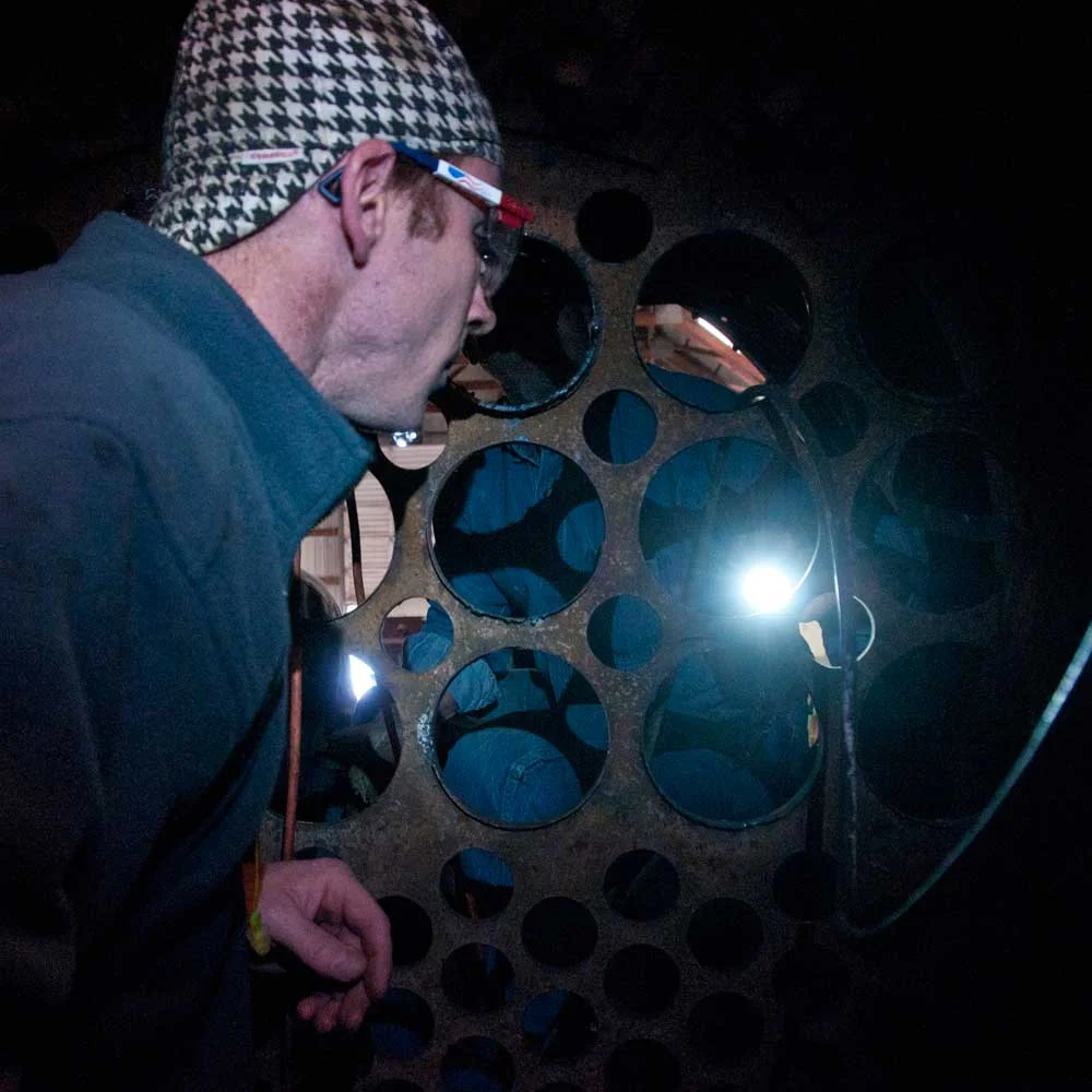 Shane Meador inspects the large 5-1/2" superheater openings in the front flue sheet of 152.
